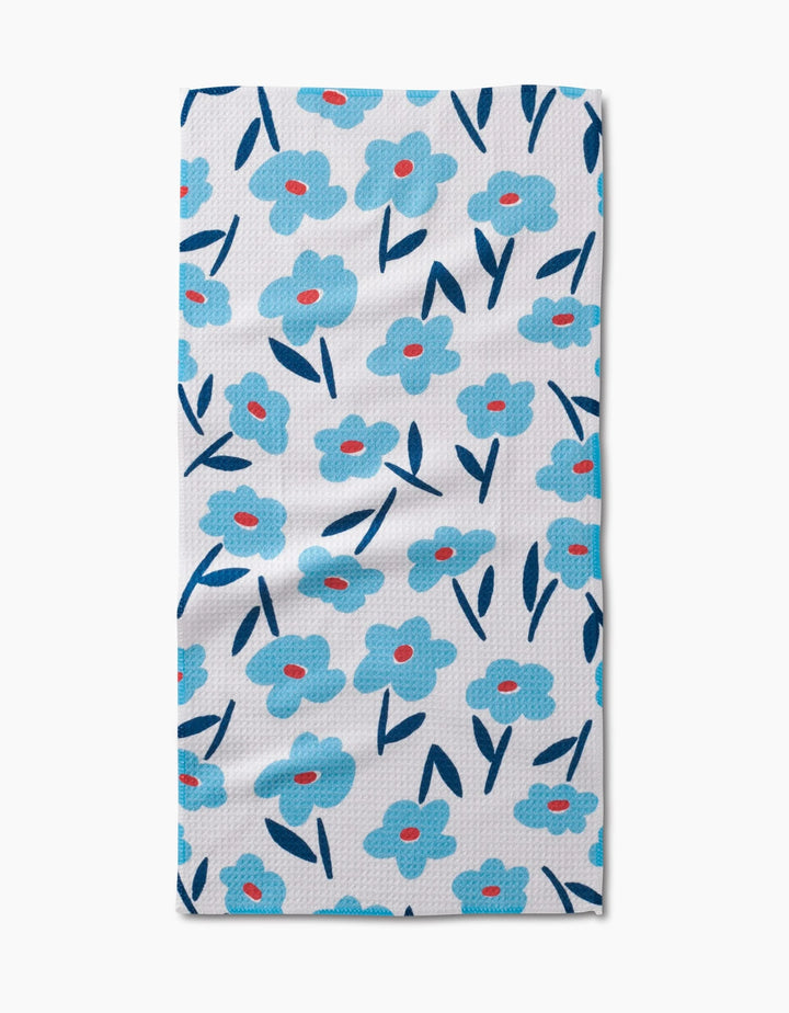 The Hufton Studio Luca Daisy is a rectangular white bar towel showcasing blue flowers with red centers and dark blue leaves, all on absorbent Geoweave fabric for stylish function.