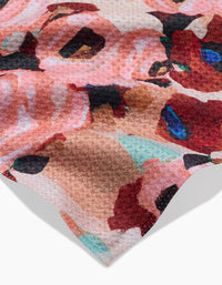 Close-up of the ultra-absorbent Lucia towel by Ania Zwara Art, featuring a textured surface and a vibrant abstract pattern in pink, red, beige, black, blue, and turquoise tones against a white background.