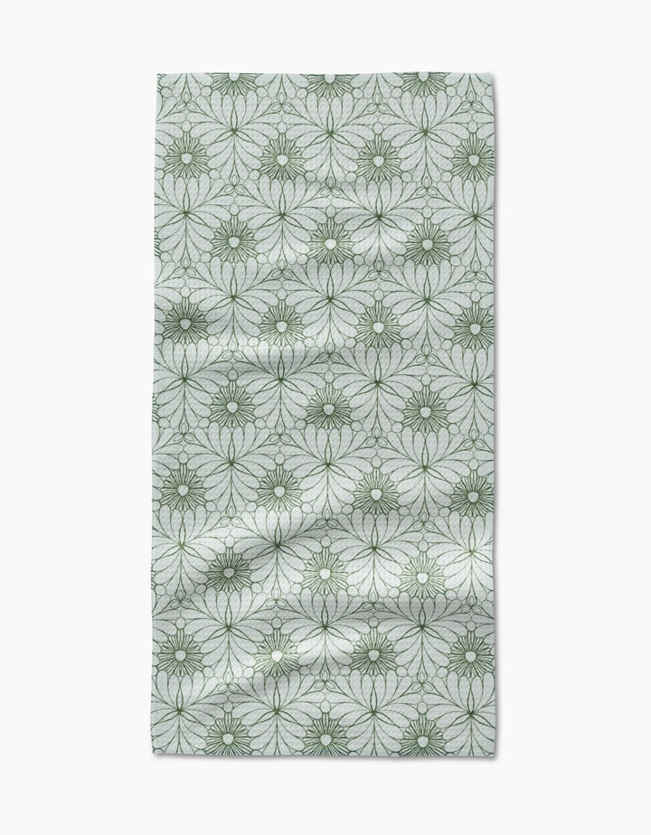 The Marta Harvey Lush Green Floral Bar Towel features ultra-absorbent Geoweave fabric with green, circular floral designs on a light gray background, showing natural folds and wrinkles.