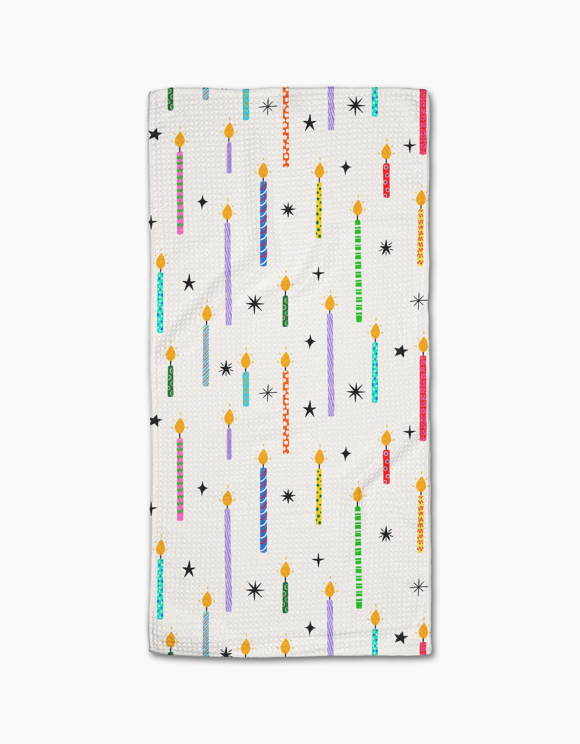 The Make A Wish bar towel by Vaishali Design Studio features colorful, lit birthday candles and black star shapes on white Geoweave fabric.