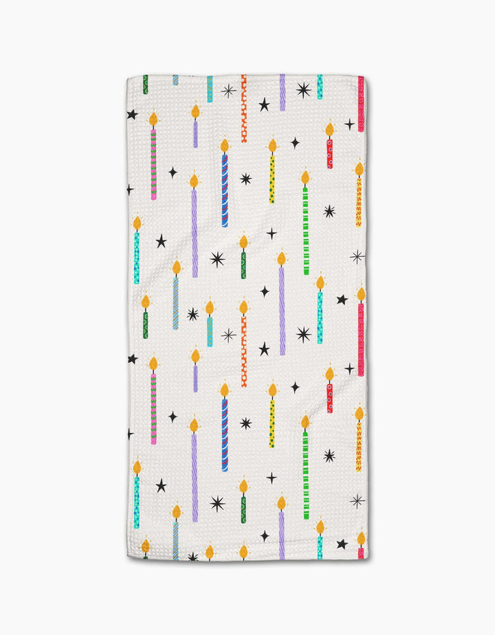The Make A Wish bar towel by Vaishali Design Studio features colorful, lit birthday candles and black star shapes on white Geoweave fabric.