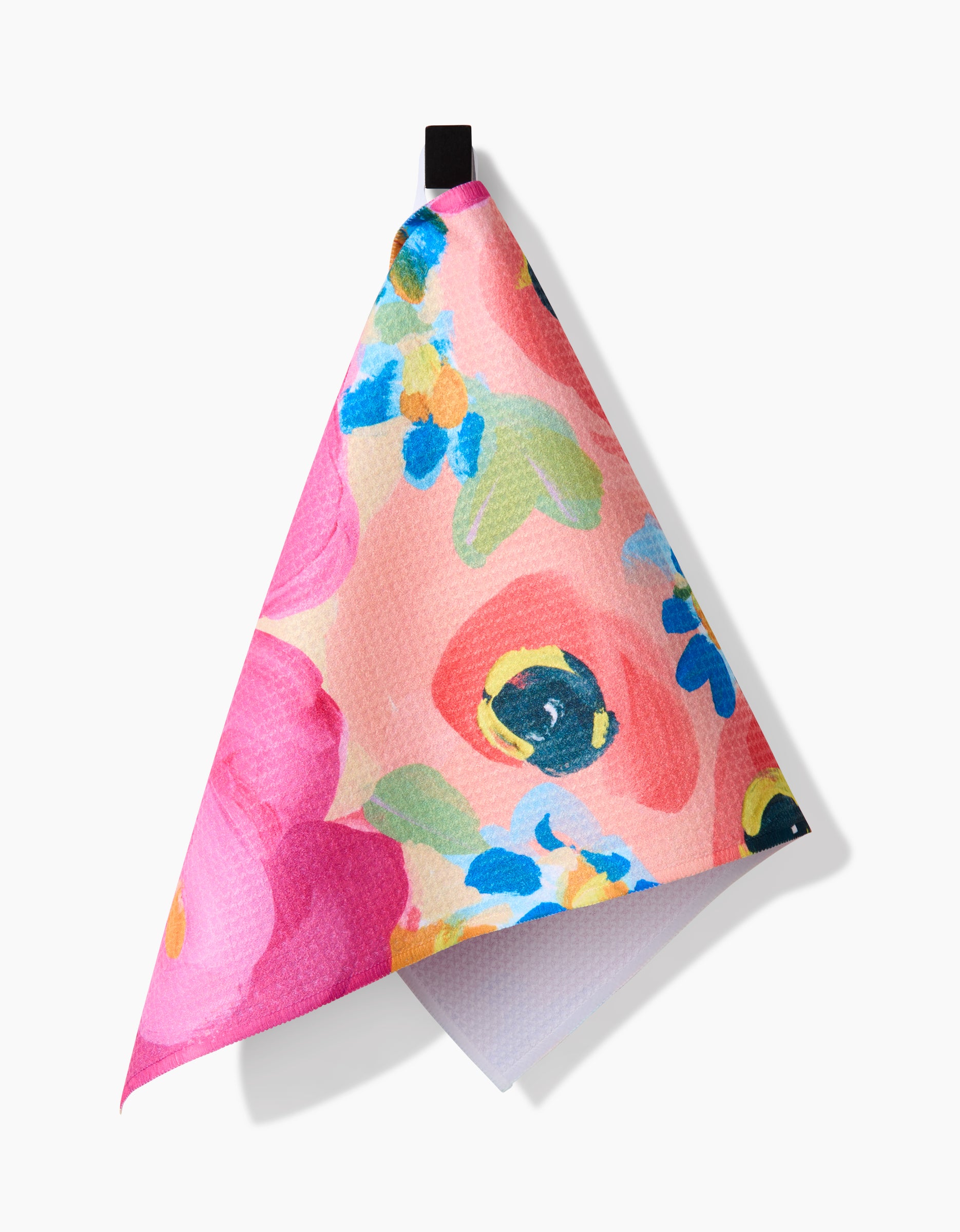 The Margot kitchen towel by Ania Zwara Art features a bright floral pattern in pink, blue, yellow, and green on Geoweave fabric. It hangs from a black loop and is displayed against a white background.