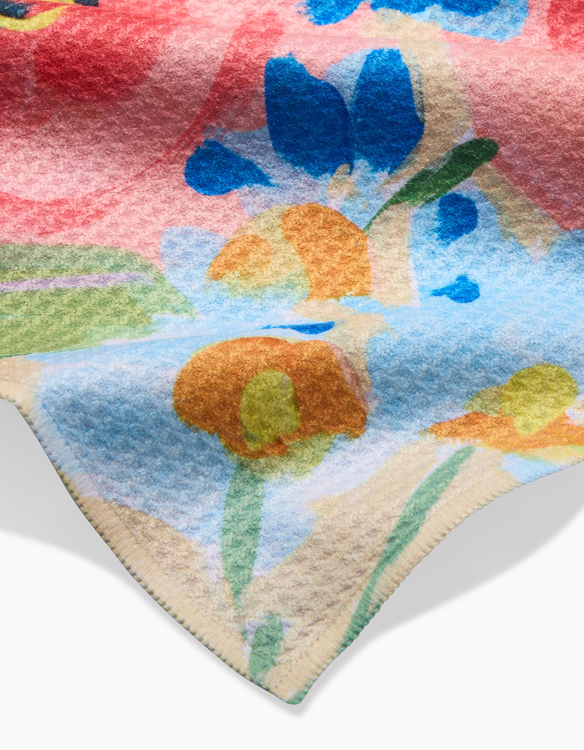 A close-up of the Margot Geoweave bar towel by Ania Zwara Art, showing its soft, textured fabric and vibrant abstract floral pattern in blue, orange, green, and red with a visible seam along the edge.