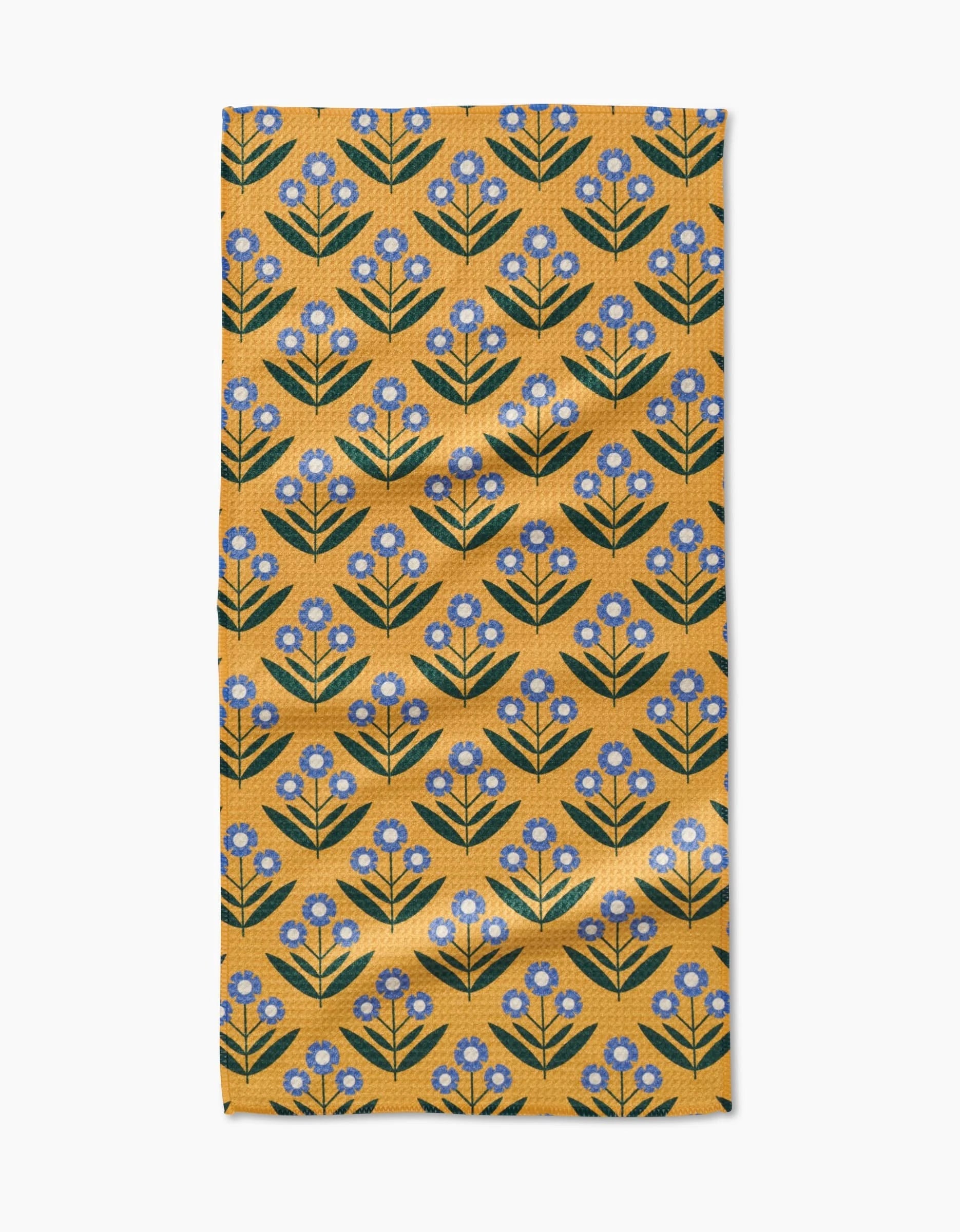 The Mayday Bar Towel by Megan Kampa features Geoweave fabric with a mustard yellow base and blue flowers with green stems arranged in neat diagonal rows.