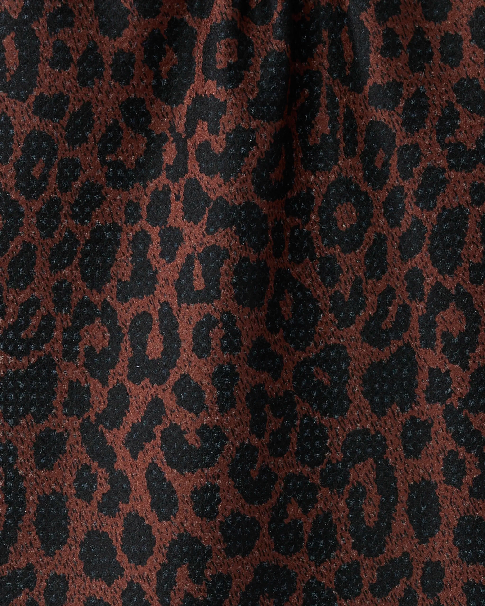Close-up of Geometry’s Midnight Safari bar towel, made from soft Geoweave fabric, featuring irregular black spots on a reddish-brown background.