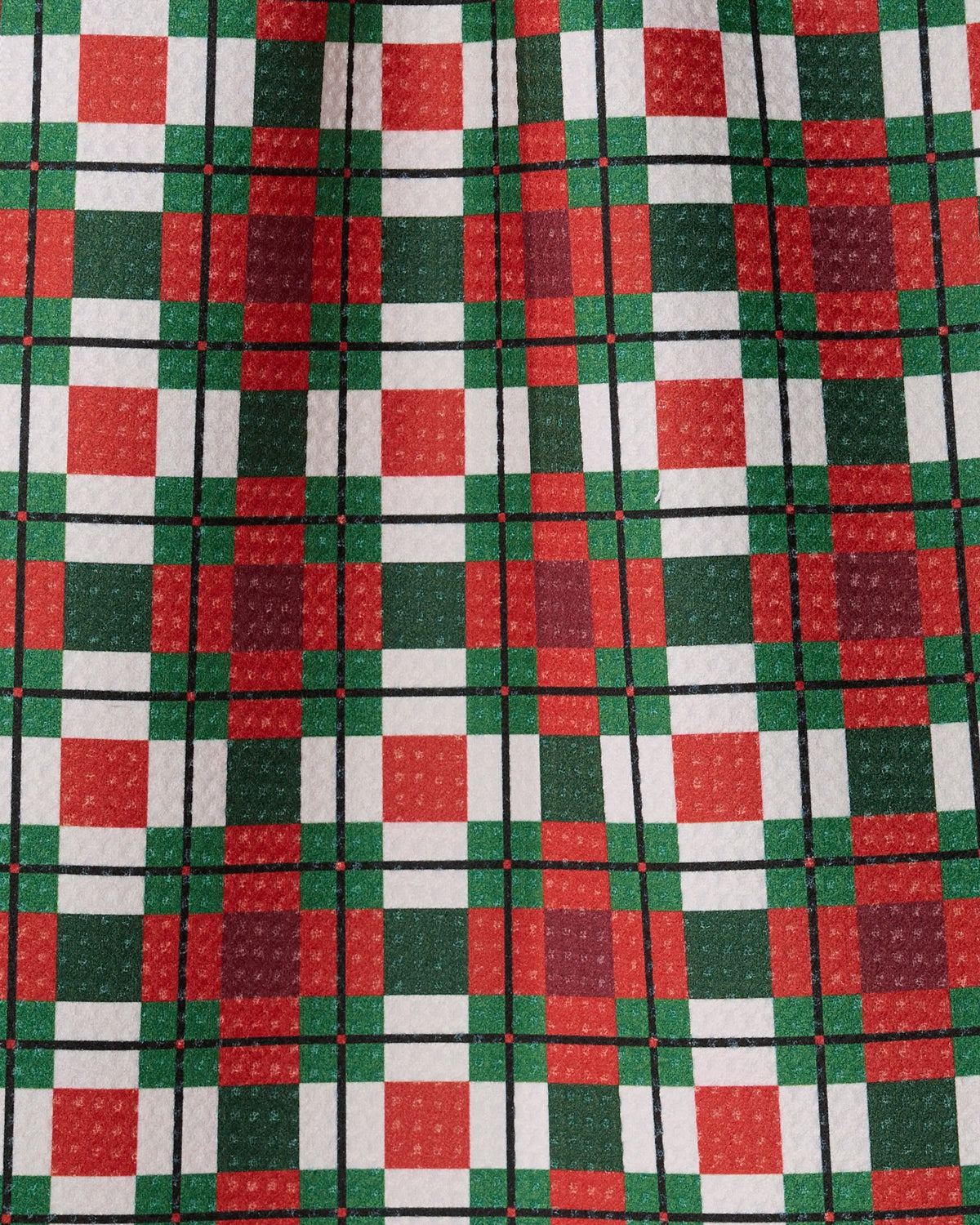 Close-up of fabric featuring the Noel Plaid pattern by Geometry, displaying a festive arrangement of red, green, and white squares and lines. Crafted from Geoweave fabric, this mini towel highlights a visible texture that enhances its cozy, holiday-inspired appeal.