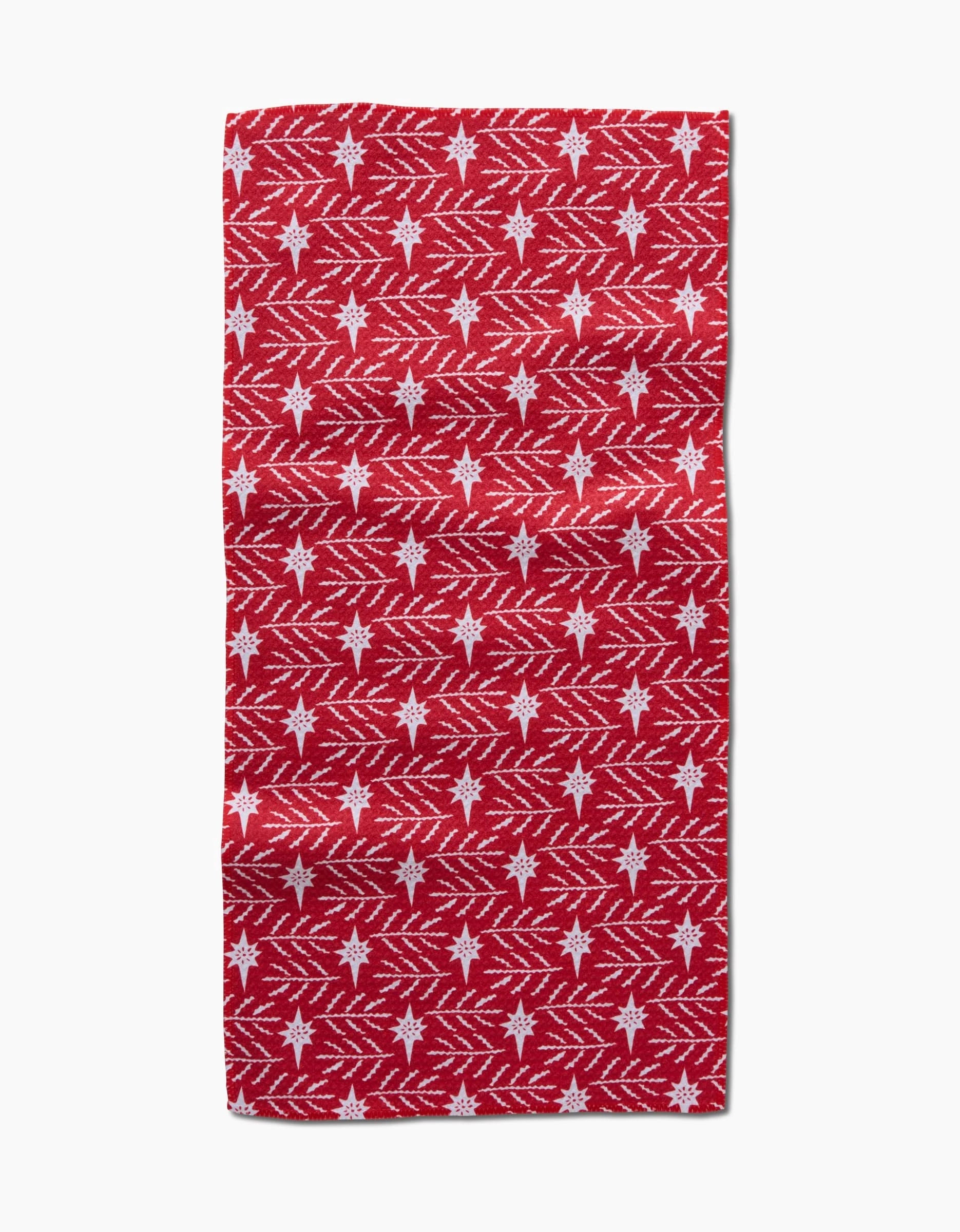 The Roxy Marj North Star kitchen towel is ultra-absorbent and rectangular, featuring a red background with white snowflakes and diagonal zigzag lines for a festive winter holiday look.