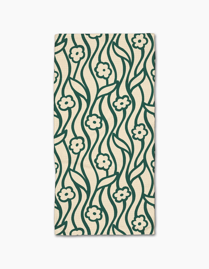 The Nostalgic Flowers kitchen towel by Gerdadzy is a rectangular beige recycled napkin featuring a dark green wavy floral pattern with small flowers and stems, symmetrically repeated across the fabric.