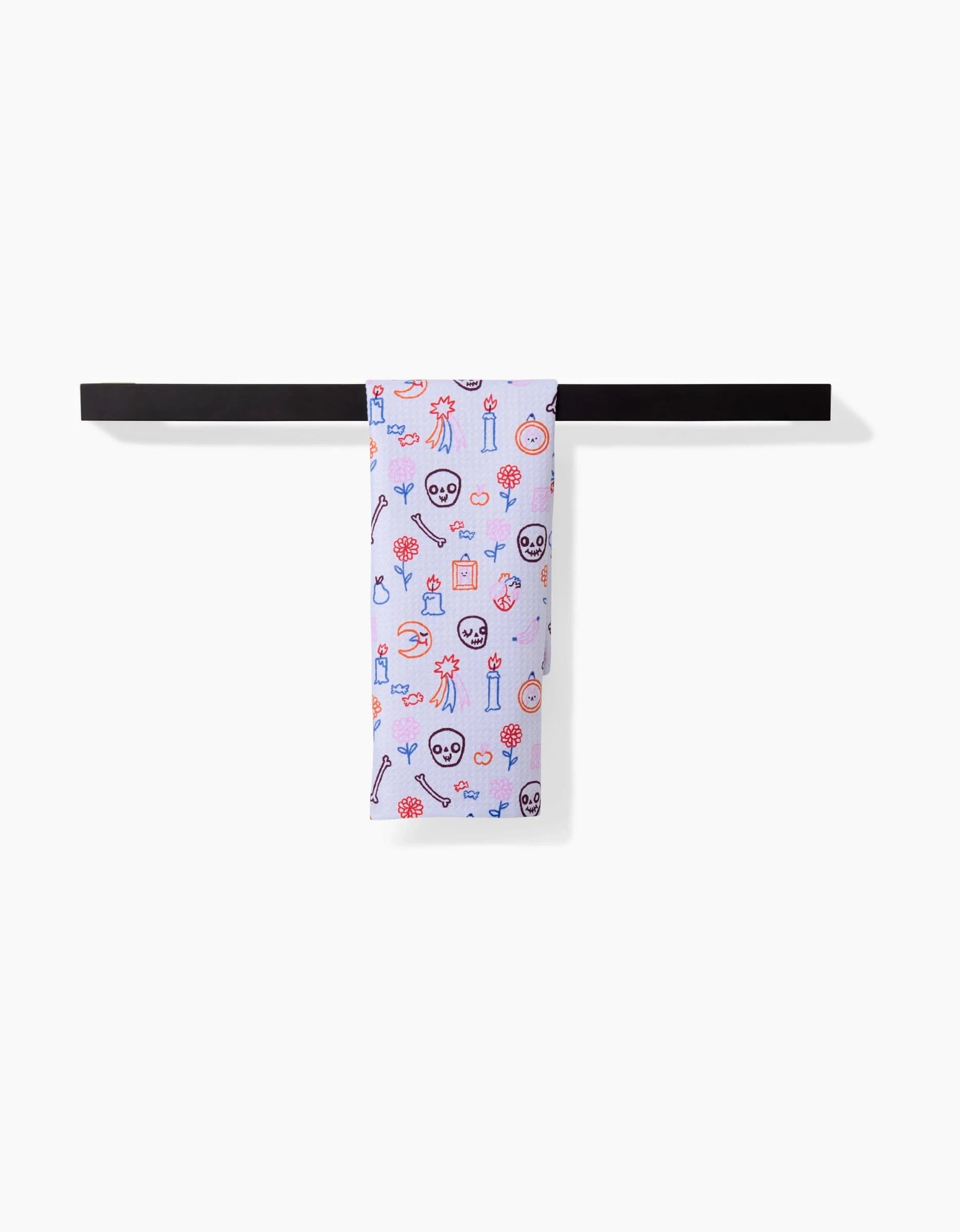 The So Lazo Offerings Bar Towel, in light purple with cheerful patterns—faces, trophies, flowers, and icons—is made of Geoweave fabric and shown draped over a black bar against a white background.