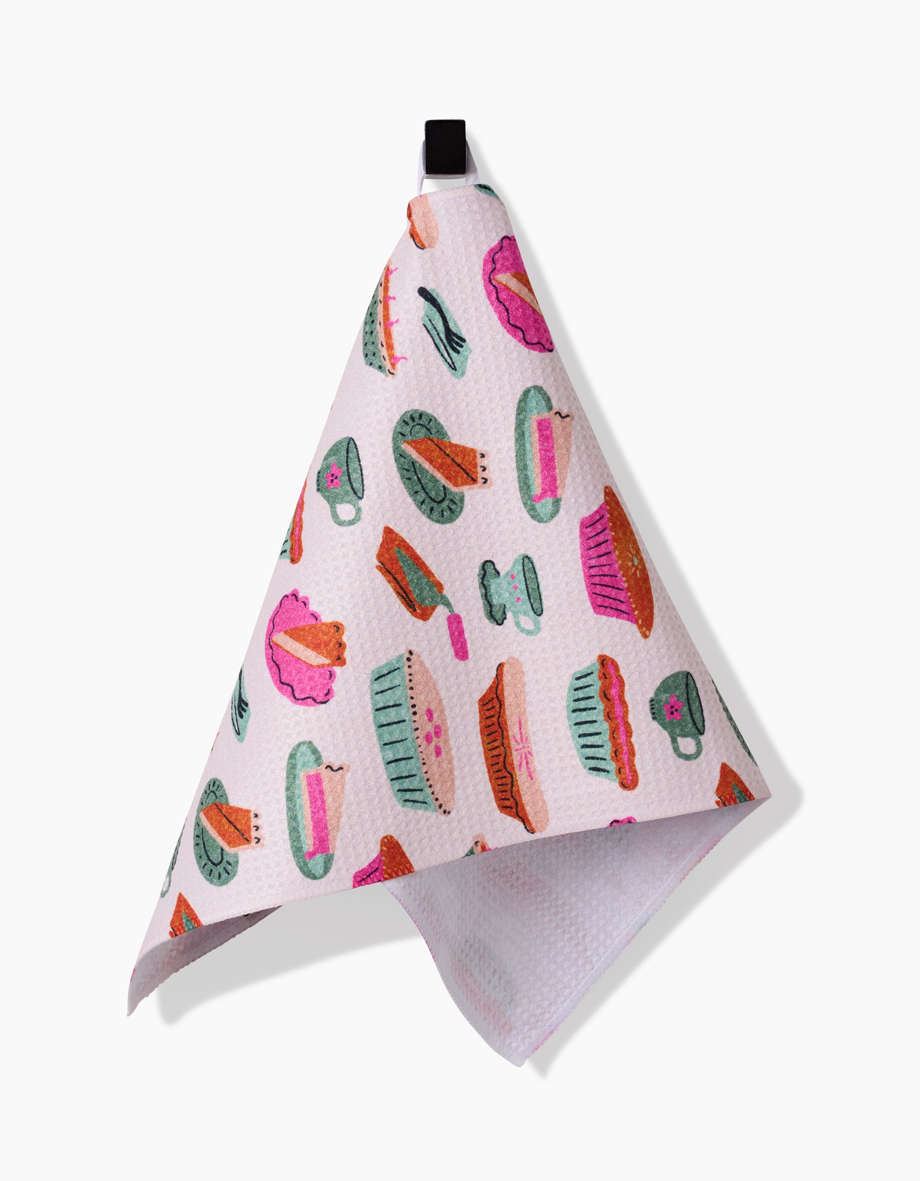 The Orla bar towel by Amy MacCready is a pink Geoweave fabric towel with vibrant teacup, teapot, and cake designs. It hangs from a black loop and adds color to any kitchen.