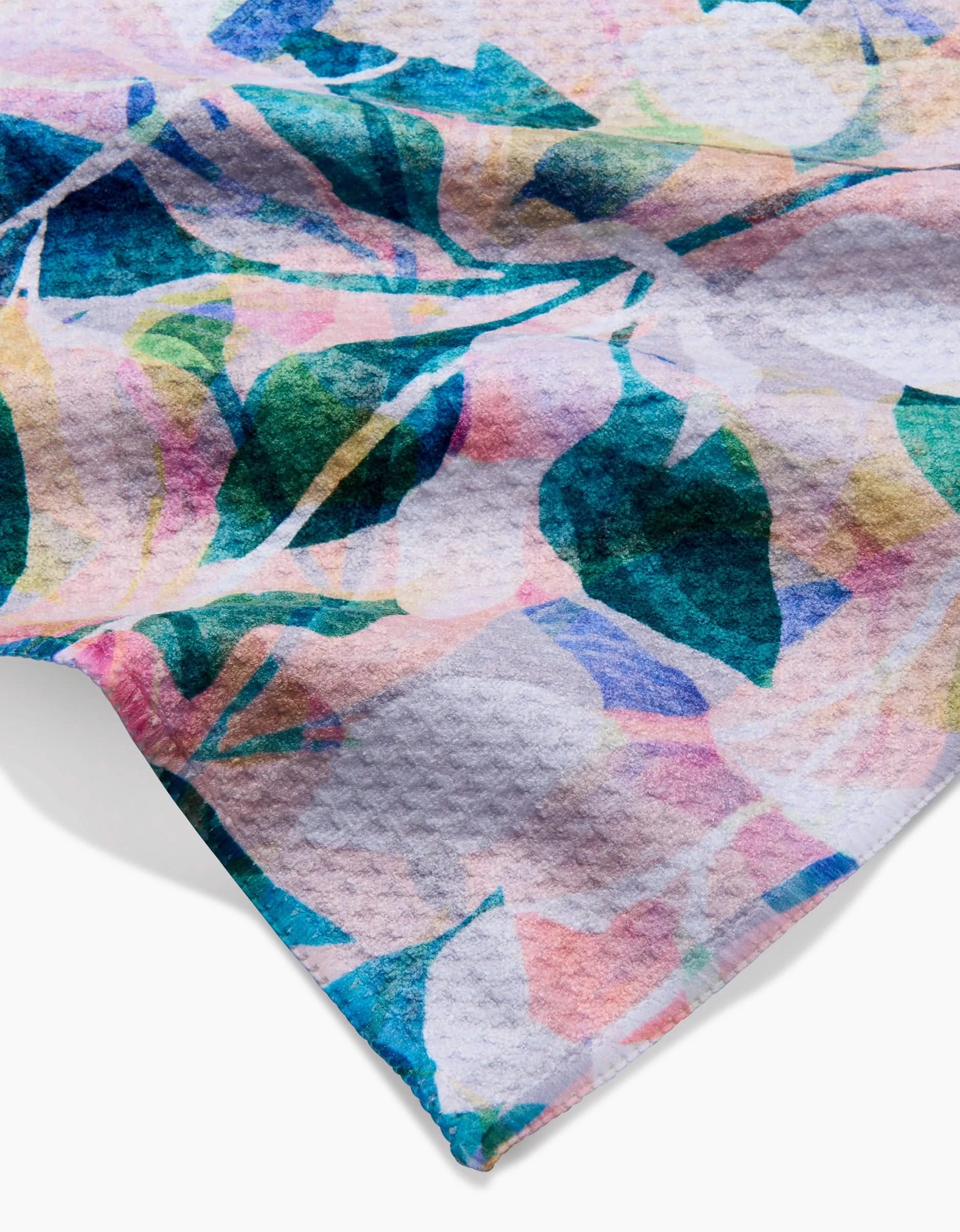 A close-up of the Painted Foliage Bar Towel by Rachel Parker, showcasing a colorful abstract floral design with blue, green, pink, and yellow shapes on textured white Geoweave fabric.