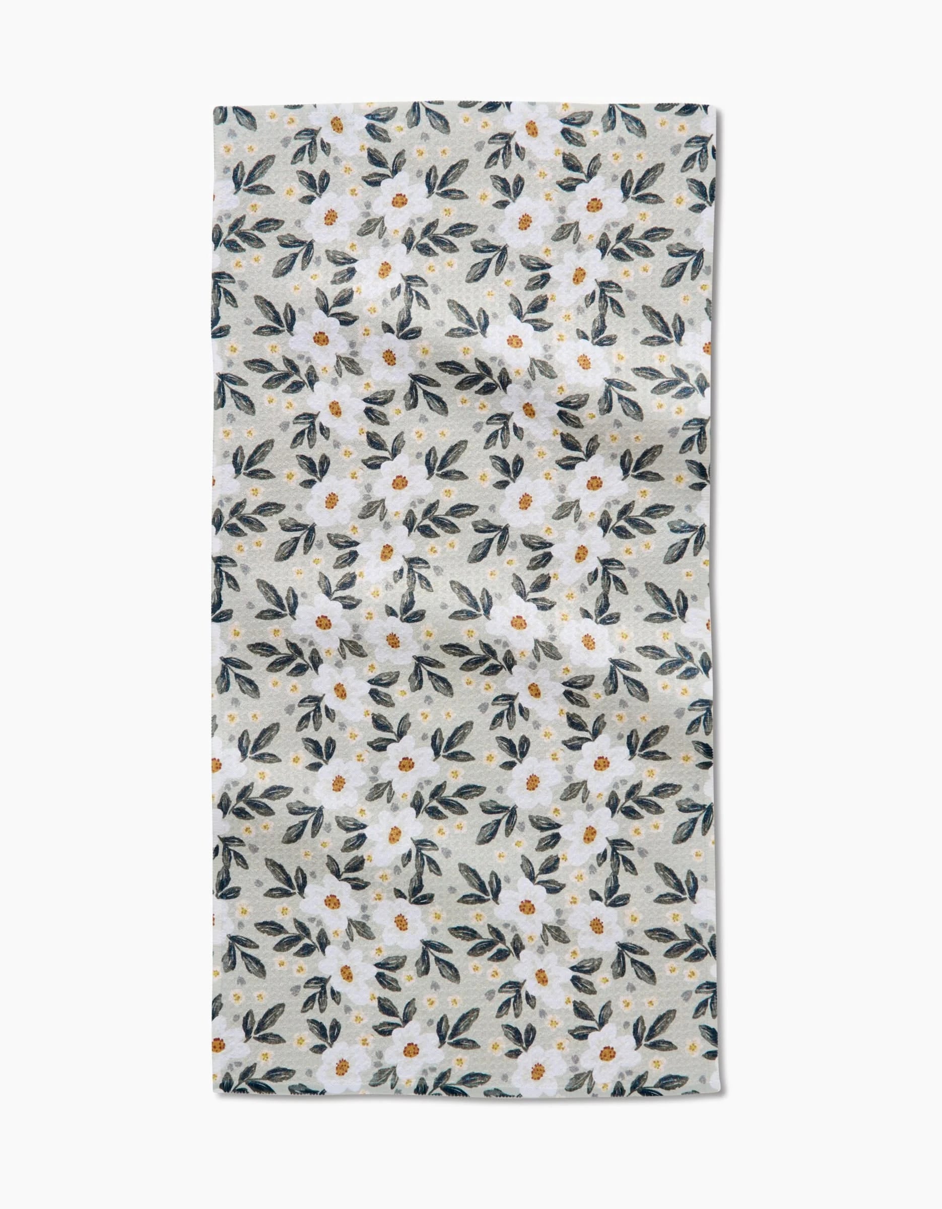 The Painted Spring Flowers Bar Towel by Teri the Butter features a white, rectangular design with small white flowers, yellow centers, and blue-green leaves on a light grey background. Made from durable Geoweave fabric.