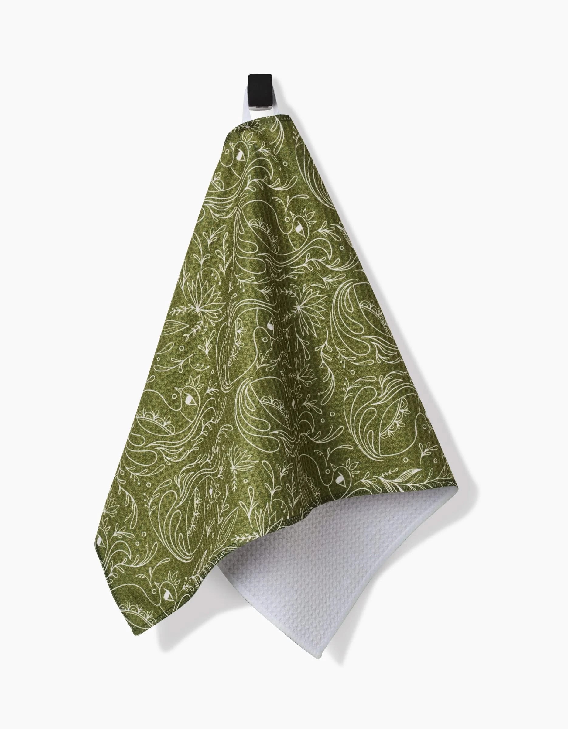 The Peacock Blooms bar towel by Amita Nair features a green floral design and white textured underside, crafted from durable Geoweave fabric. It hangs from a black loop and is shown against a white background.