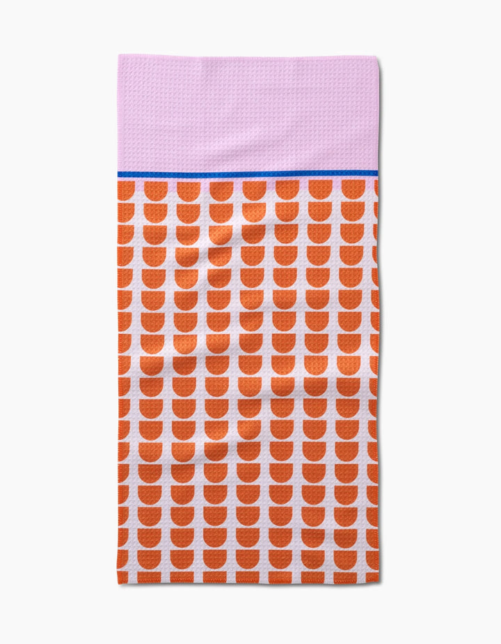 The Happy Hemera Pink Illusion is a rectangular bar towel made from recycled materials, with a light purple top, blue stripe, and white lower section with orange semicircles.
