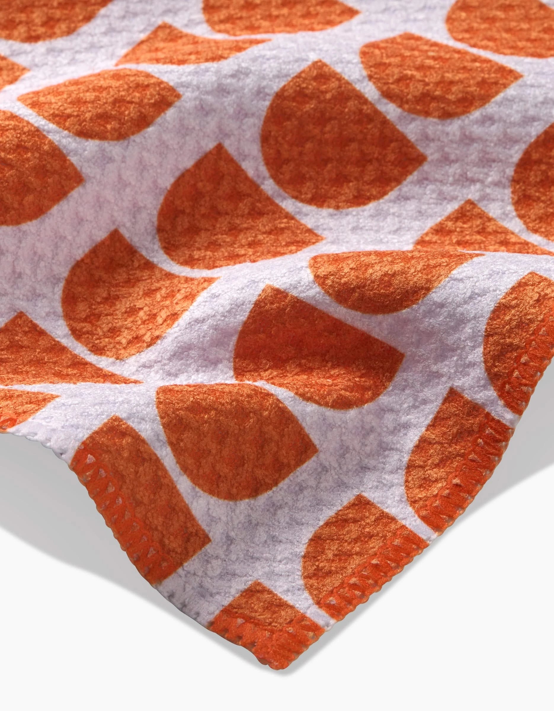 A close-up of the Happy Hemera Pink Illusion Geoweave bar towel, showcasing soft fabric with a bold pink semicircle pattern on white and matching pink stitching along the edge.