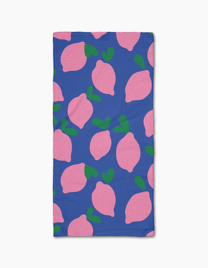 The Jennifer Bouron Pink Lemons Bar Towel features a blue background with pink lemons and green leaves, made from soft Geoweave fabric for excellent absorbency.
