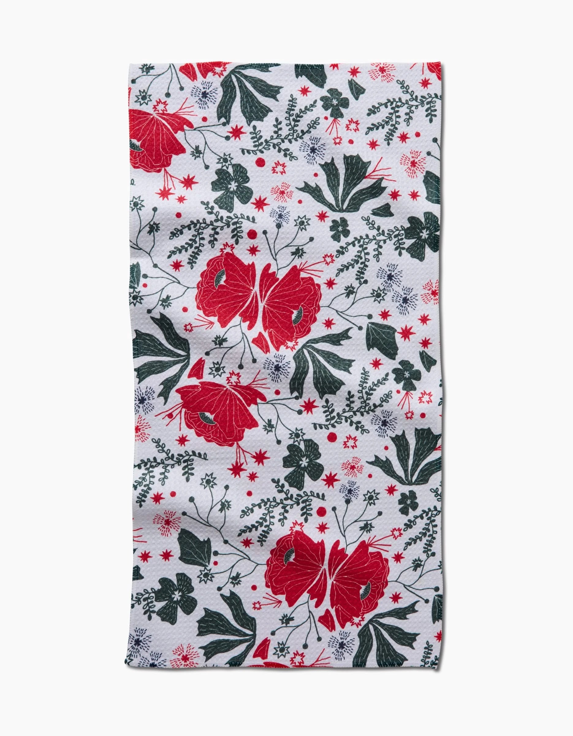The Ash Cascade Poinsettia Bramble towel is a rectangular, ultra-absorbent piece with a floral pattern of large red flowers, green leaves, and small white and red blossoms on a white background.