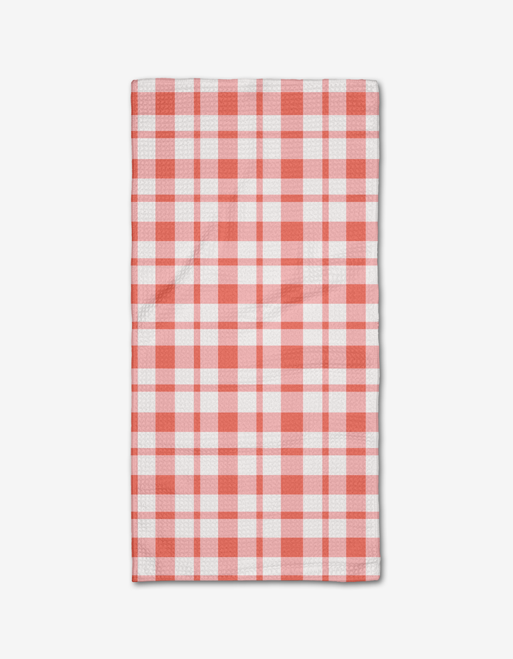 The Pretty in Pink Plaid Bar Towel by Charlie Rowan Designs features a pink plaid pattern and is neatly folded on a plain white background.