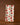 The Geometry Pumpkin Pop towel, ultra-absorbent and white with green and orange pumpkin patterns, hangs by two clothespins on a string against a brown background.