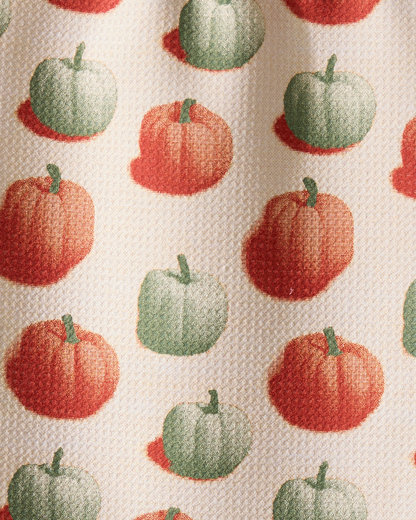 The Geometry Pumpkin Pop bar towel features rows of red-orange and green pumpkins with shadows on a light beige background. Ultra-absorbent with a visible textured finish, it combines function and festive charm.