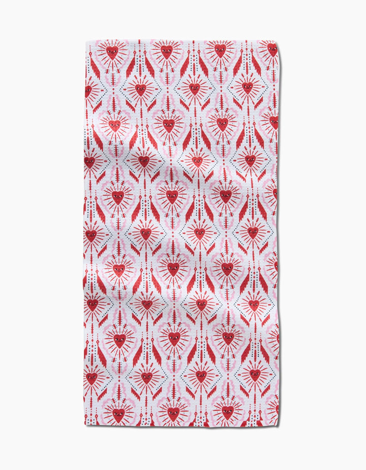 The Ray of Love towel by Roxy Marj is a rectangular, ultra-absorbent towel with a symmetrical red and pink heart pattern and radiating lines on a white background.