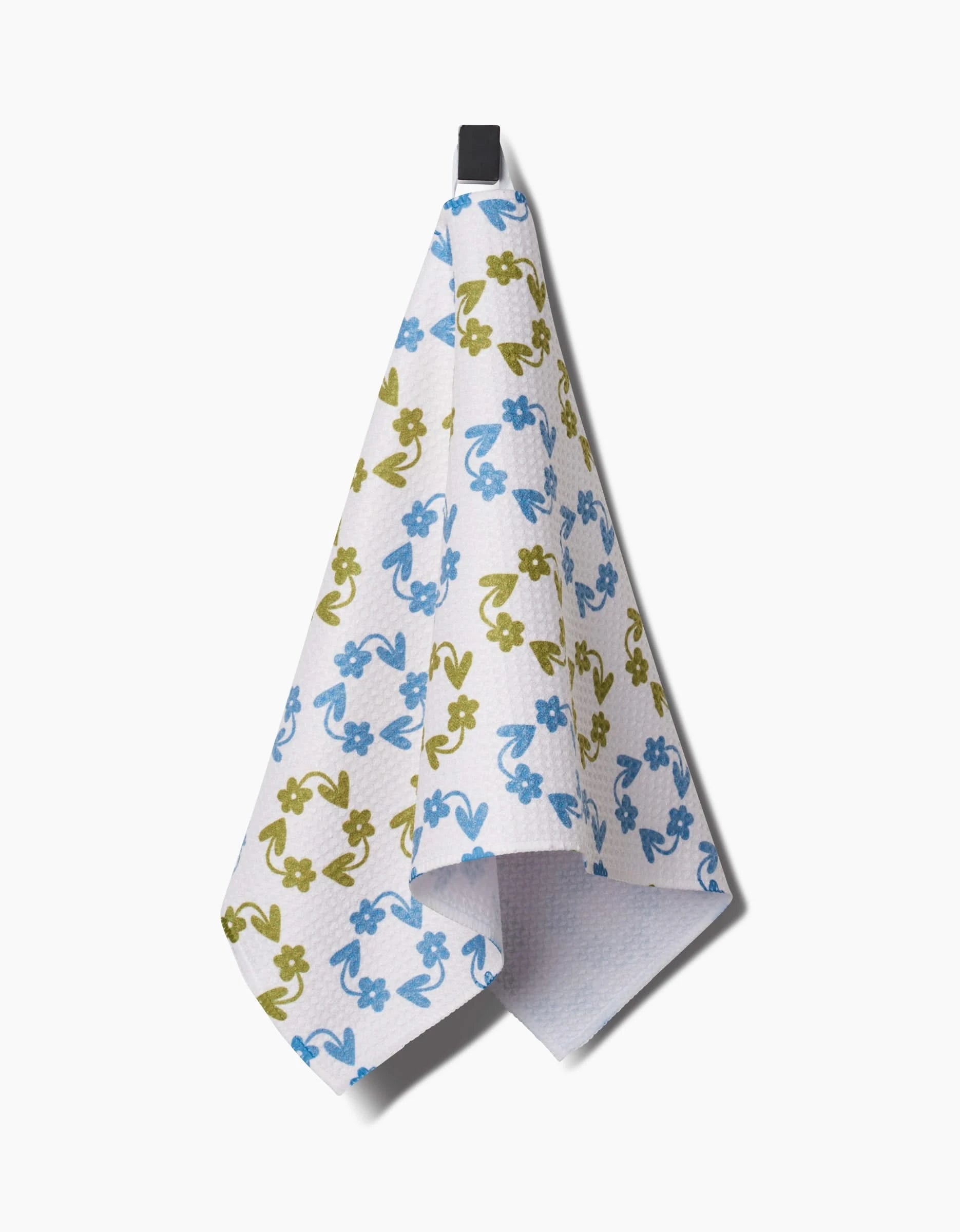 The Kayla Ann Recycled Floral bar towel features blue and green flowers on white, hanging from a black loop. Made from ultra-absorbent, post-consumer recycled materials, its a stylish and eco-friendly choice for your home.