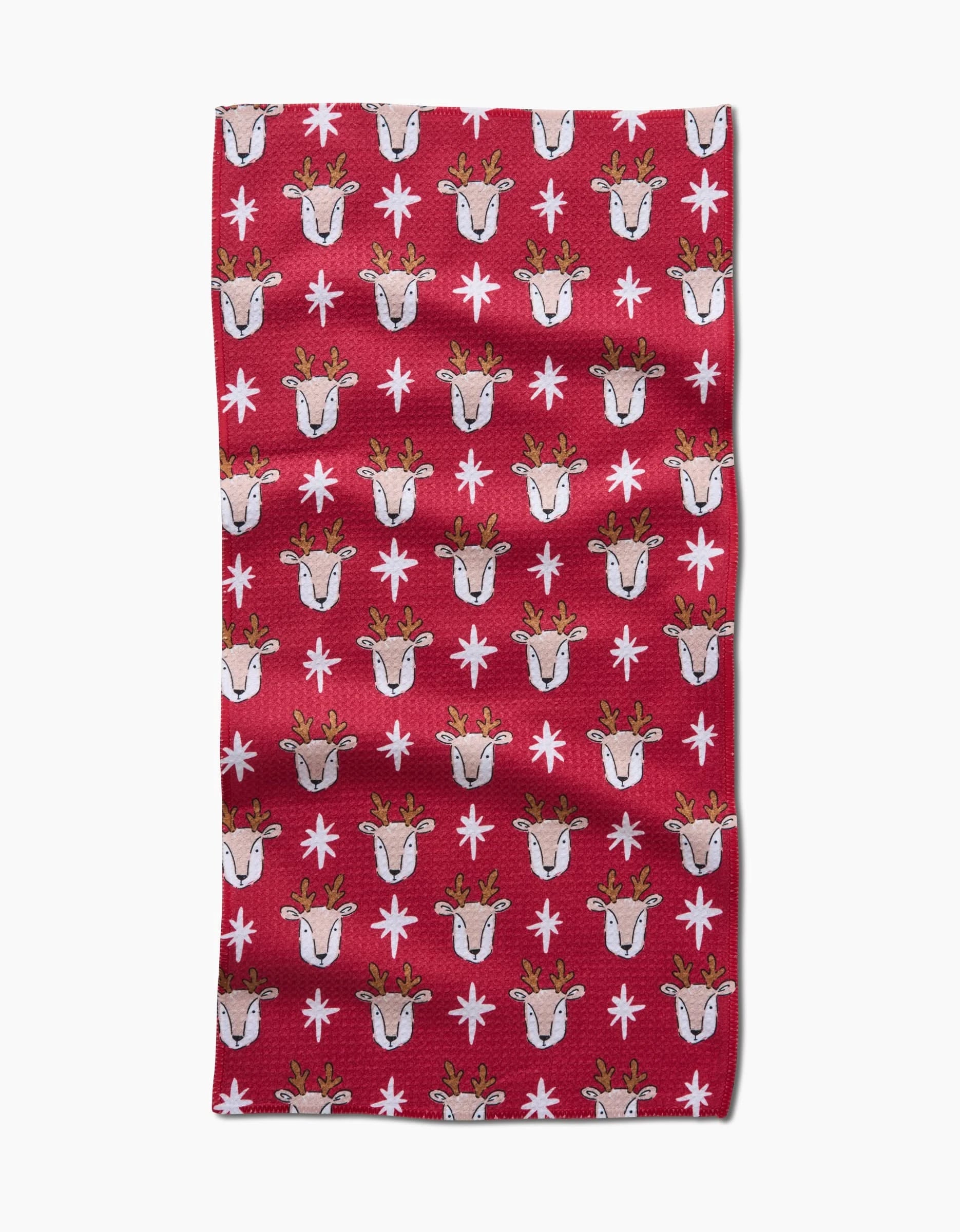 The Reindeer Star by Hufton Studio is a red rectangular bar towel made from recycled materials, featuring rows of cartoon reindeer heads with antlers and white snowflakes.