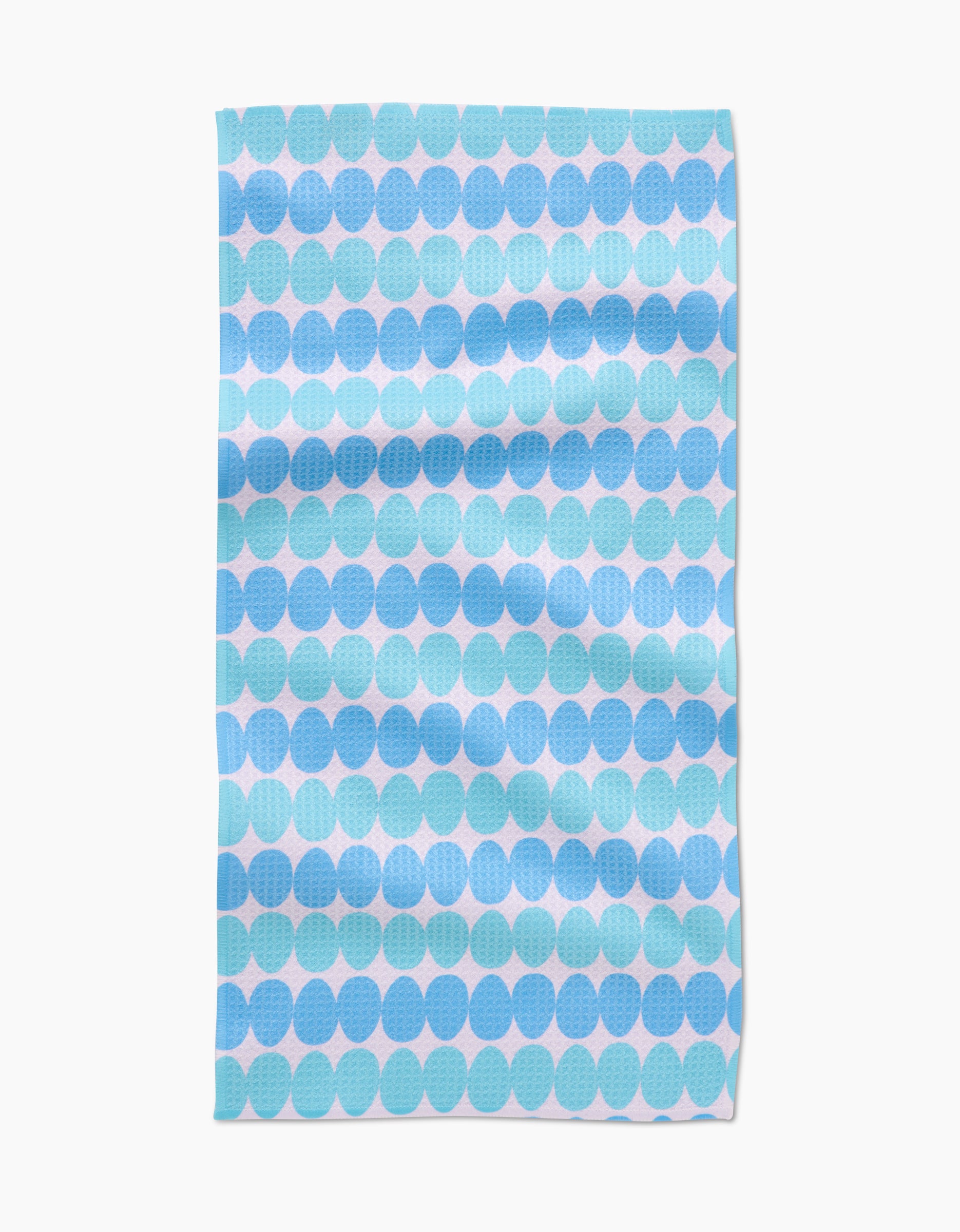 The Kayla Ann Robins Egg Bar Towel features a blue and light blue circle pattern on white Geoweave fabric. With visible folds and a slightly textured surface, it combines style with durability.