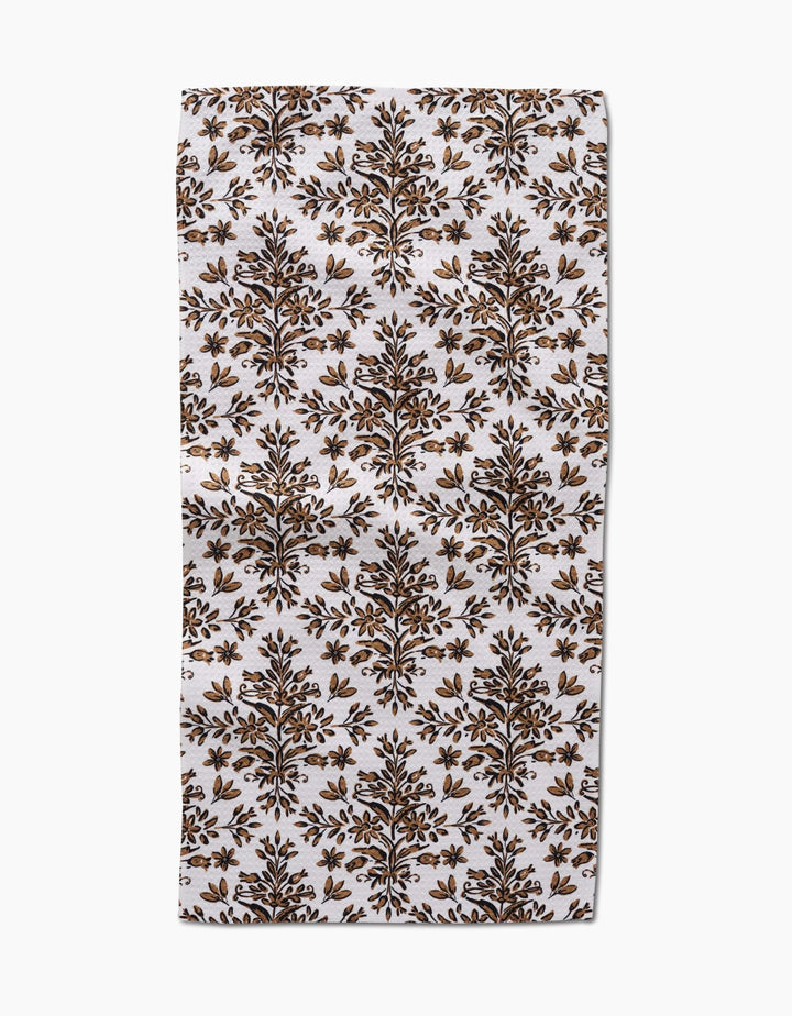 The Rustic Lacy Tile Natural by Hufton Studio is a rectangular white recycled kitchen towel with a repeating brown and gold botanical pattern of symmetrical tree motifs arranged in rows.