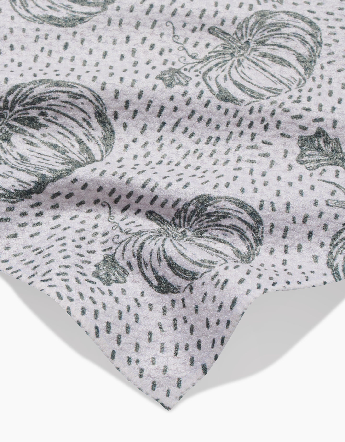 A light gray Sage Pumpkin Field bar towel by Charlie Rowan Designs features a black pumpkin and dotted line pattern. The fabric is slightly wrinkled, with the edge visible in the lower corner.