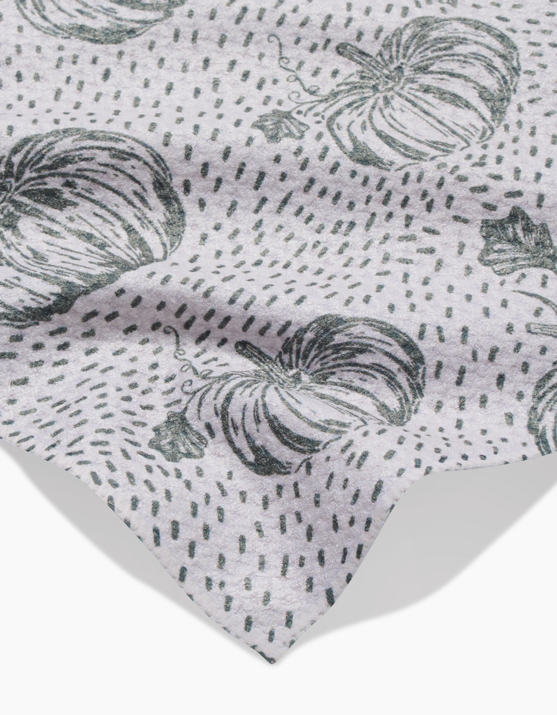 A light gray Sage Pumpkin Field bar towel by Charlie Rowan Designs features a black pumpkin and dotted line pattern. The fabric is slightly wrinkled, with the edge visible in the lower corner.