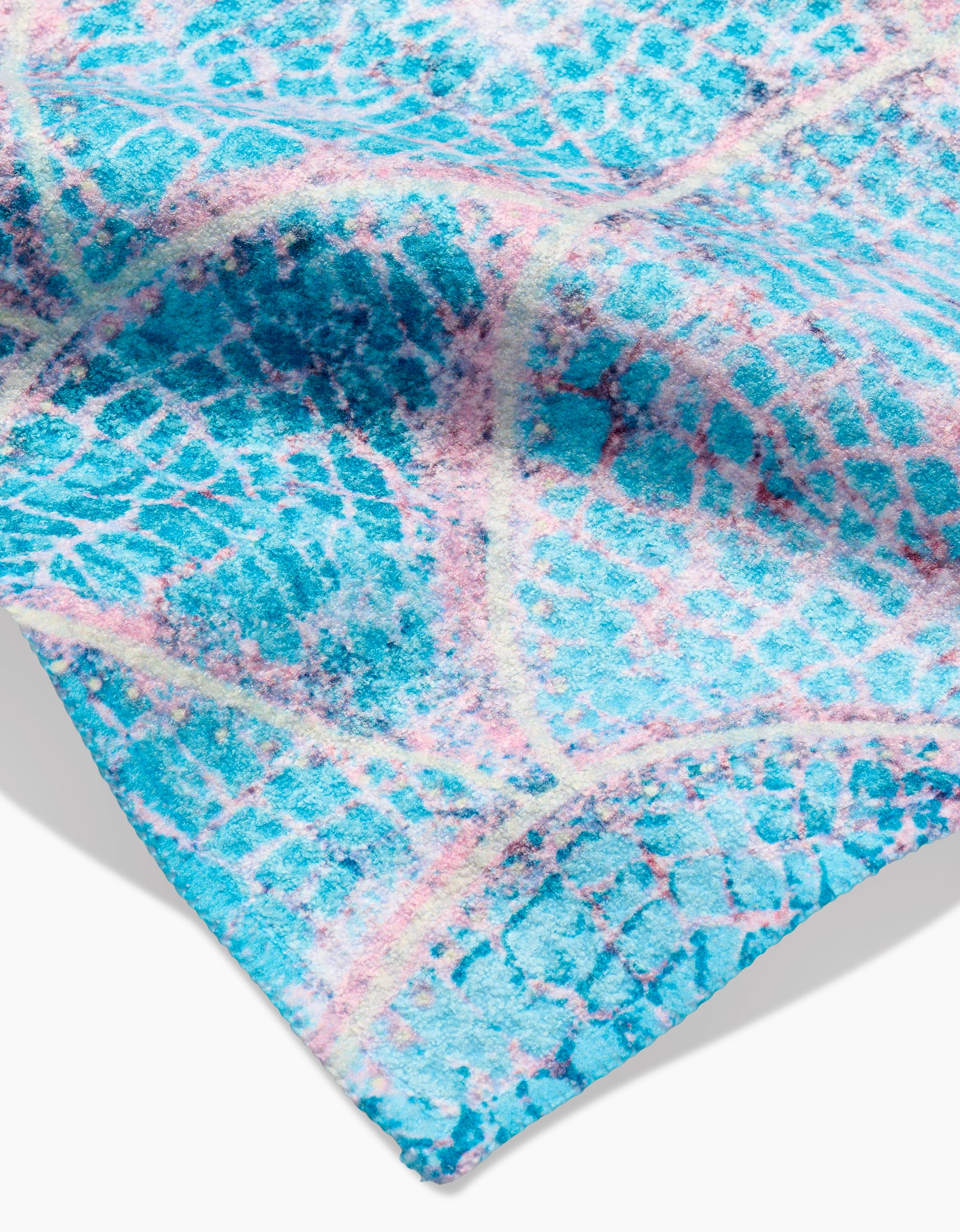 A close-up of the Scallop Hills Bar Towel by Taryn Brennan, featuring textured blue Geoweave fabric with a wavy abstract pattern in blue, white, and pink reminiscent of water or mosaic tiles.