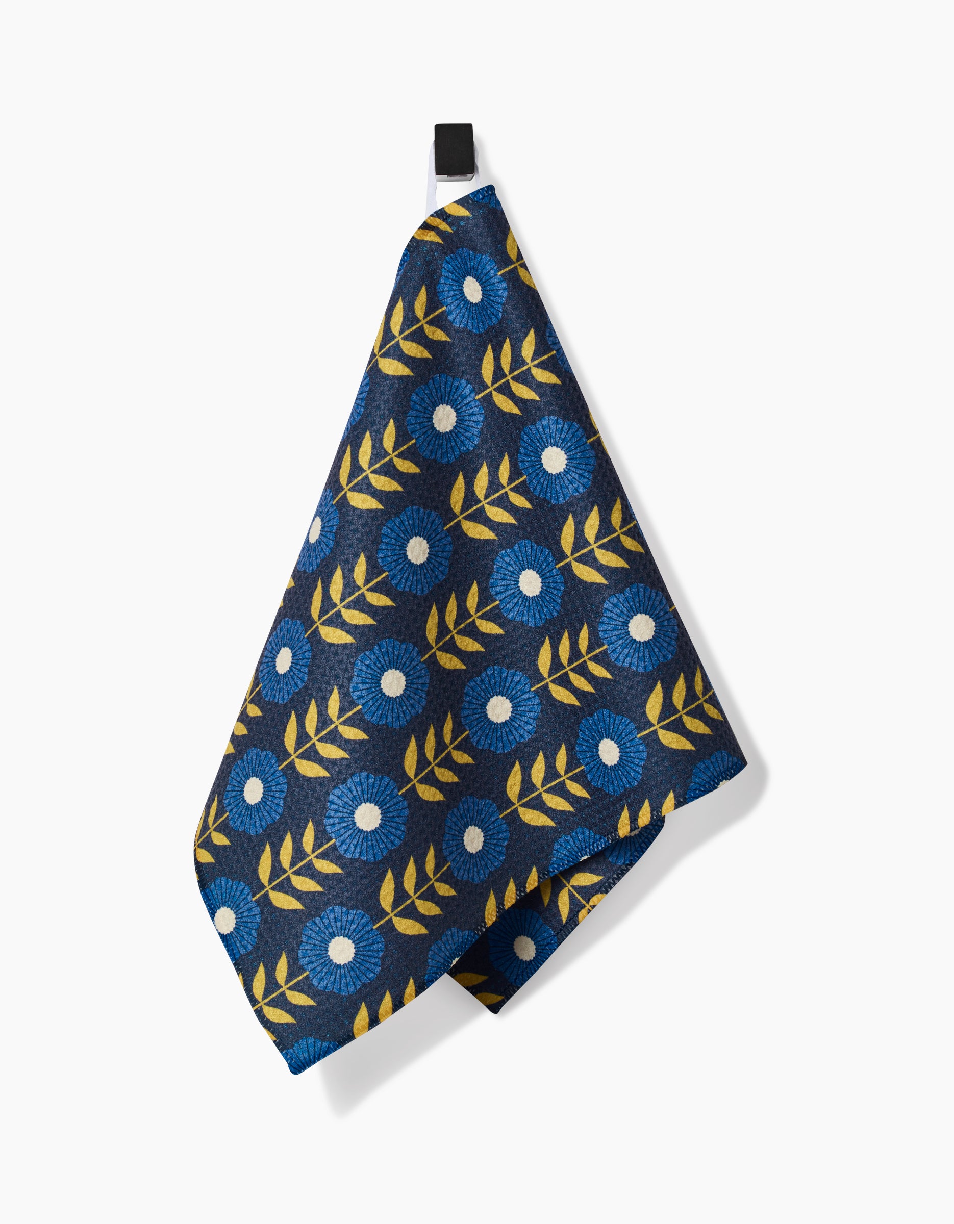 The Scandi Floral Bar Towel by Megan Kampa is made from eco-friendly Geoweave fabric and features a blue and white floral pattern with yellow leaves, shown hanging from a black loop against a white background.