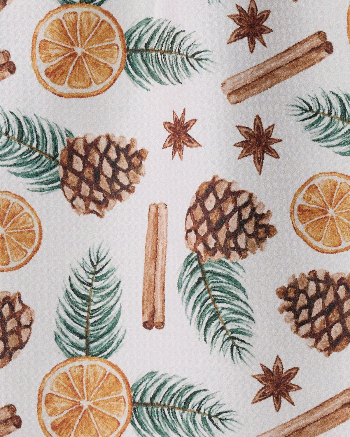 The “Simmer Pot” mini towel by Geometry showcases a watercolor pattern of pinecones, orange slices, pine needles, star anise, and cinnamon sticks on a textured white background. Crafted from recycled materials with durable Geoweave fabric, this towel combines lasting absorbency with beautiful design.