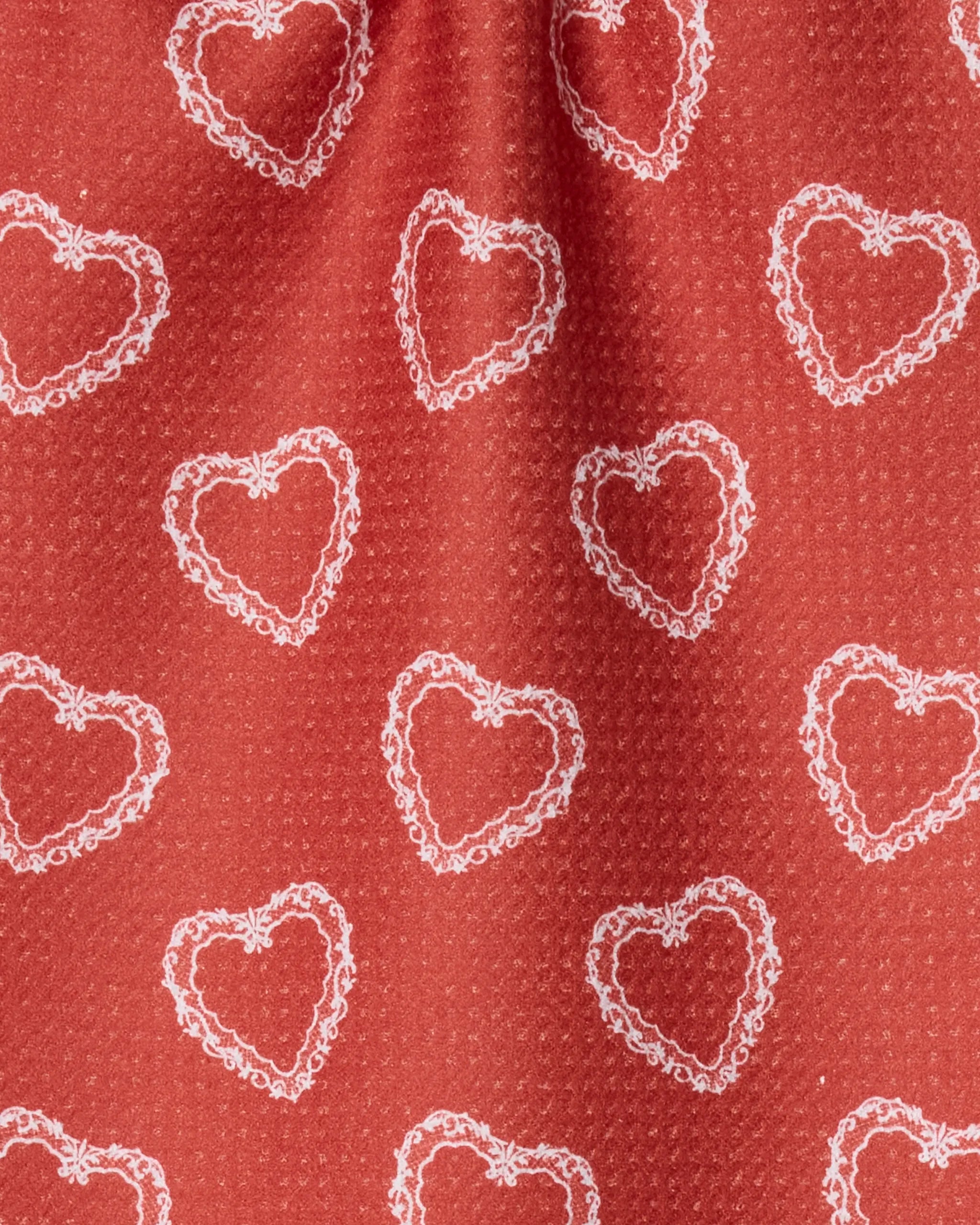Geometry’s Soft Heart Scarlet: a red, textured bar towel made from recycled materials, featuring a repeating white lace-like heart pattern—stylish and sustainable.