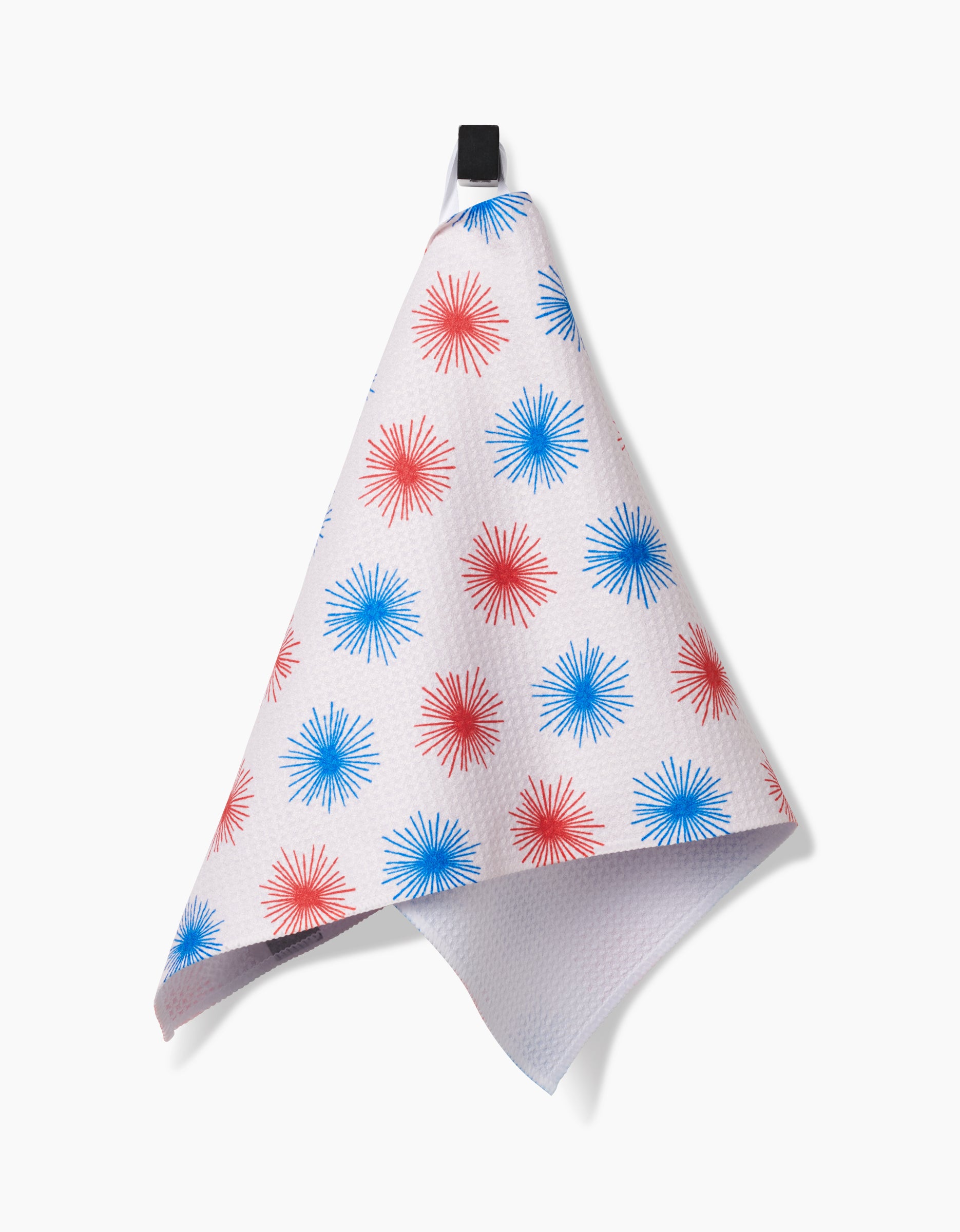The Kayla Ann Sparkler Splash Bar Towel, made from Geoweave fabric with red and blue starburst patterns, hangs by a black loop against a plain white background.