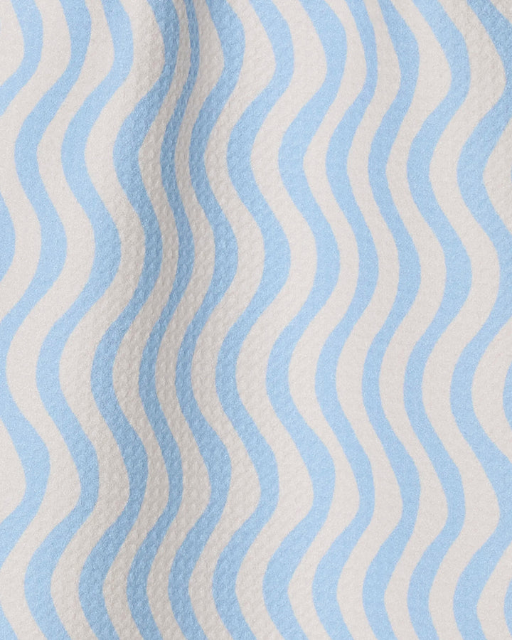 Experience Geometry's Spatial towel: featuring a textured, ultra-absorbent surface with evenly spaced wavy blue and white lines in a slightly raised, embossed pattern.