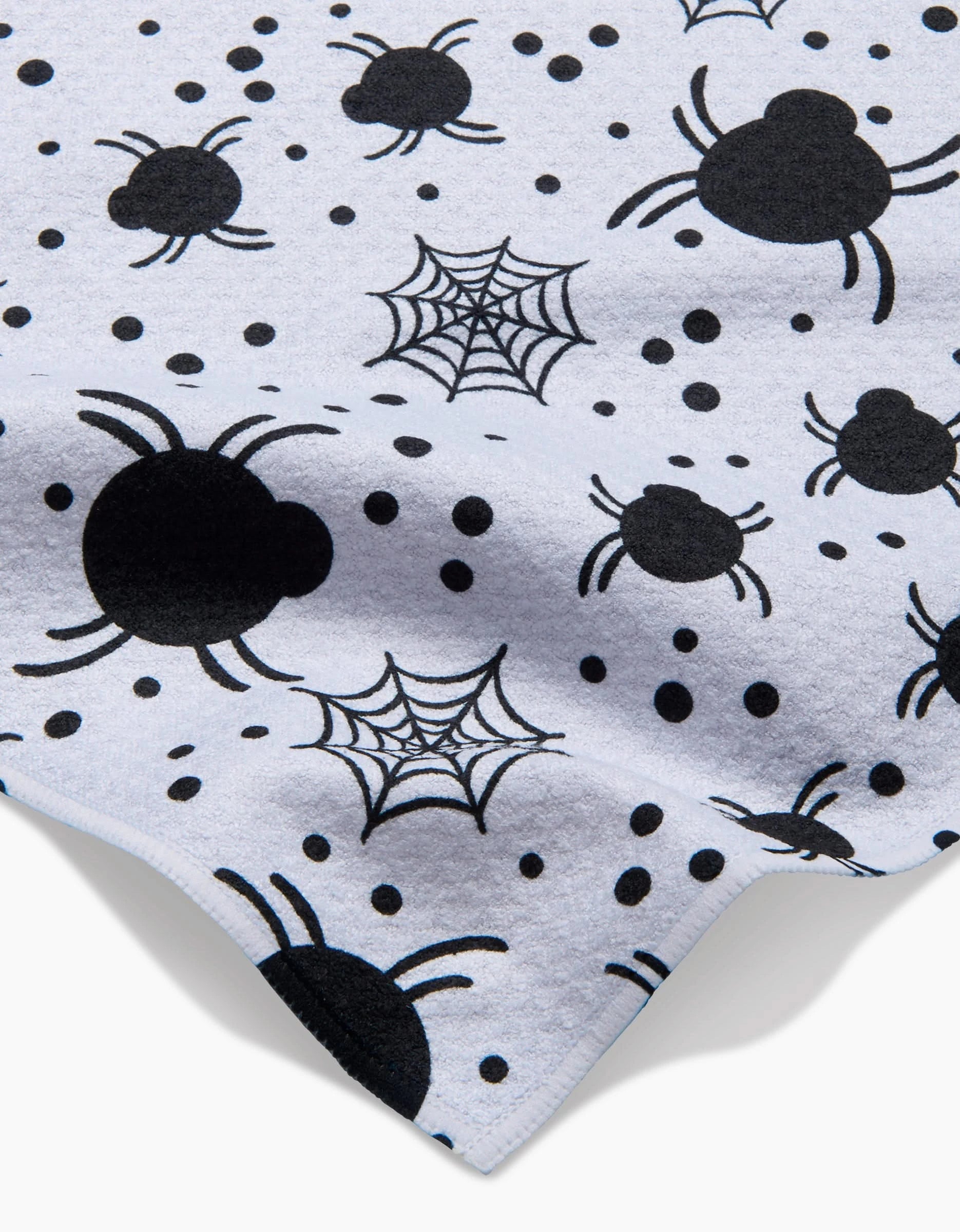 The Spiders For Days kitchen towel by Charlie Rowan Designs is ultra-absorbent and white, featuring a close-up of black spiders, spider webs, and black dots scattered across the surface.