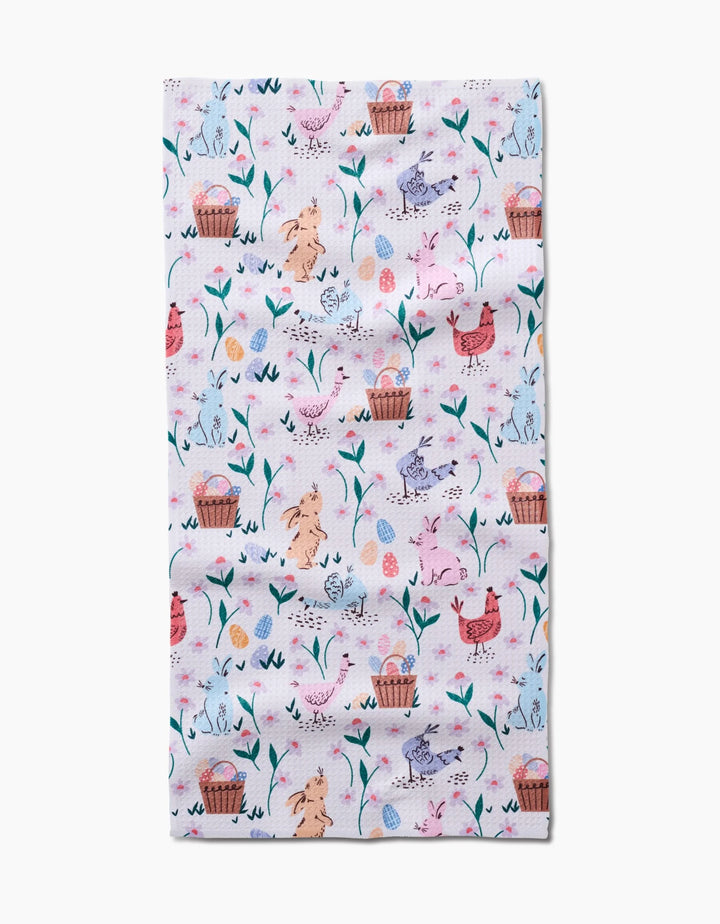 Bring festive charm to your home with the “Spring Bunnies” towel by Charlie Rowan Designs—an ultra-absorbent, pastel Easter-themed towel adorned with rabbits, chicks, eggs, baskets, and flowers on a white background.