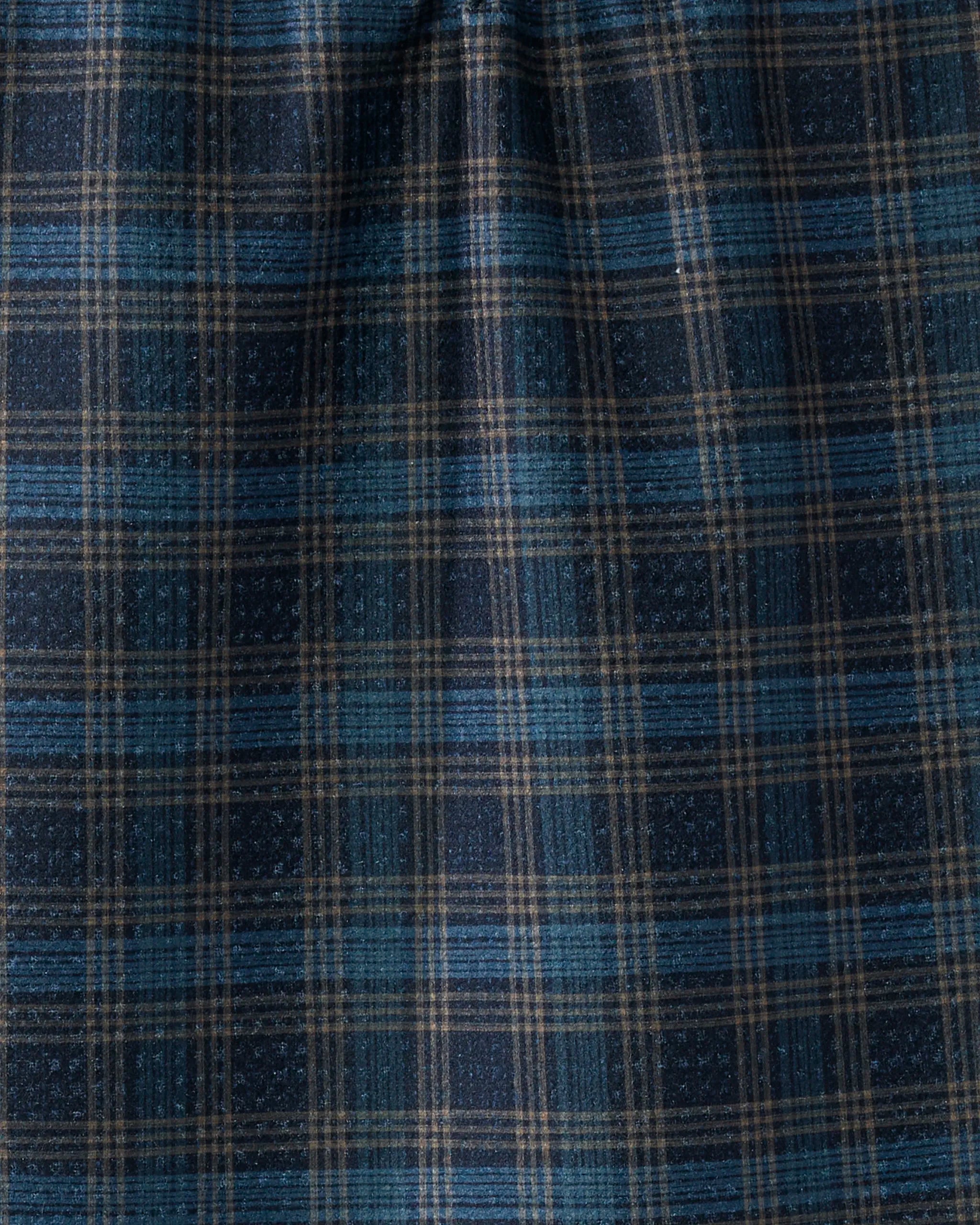 The Stonegate towel by Geometry features a blue, black, and beige plaid grid design. Made from recycled materials, this ultra-absorbent towel has a slightly wrinkled texture with vertical and horizontal lines.