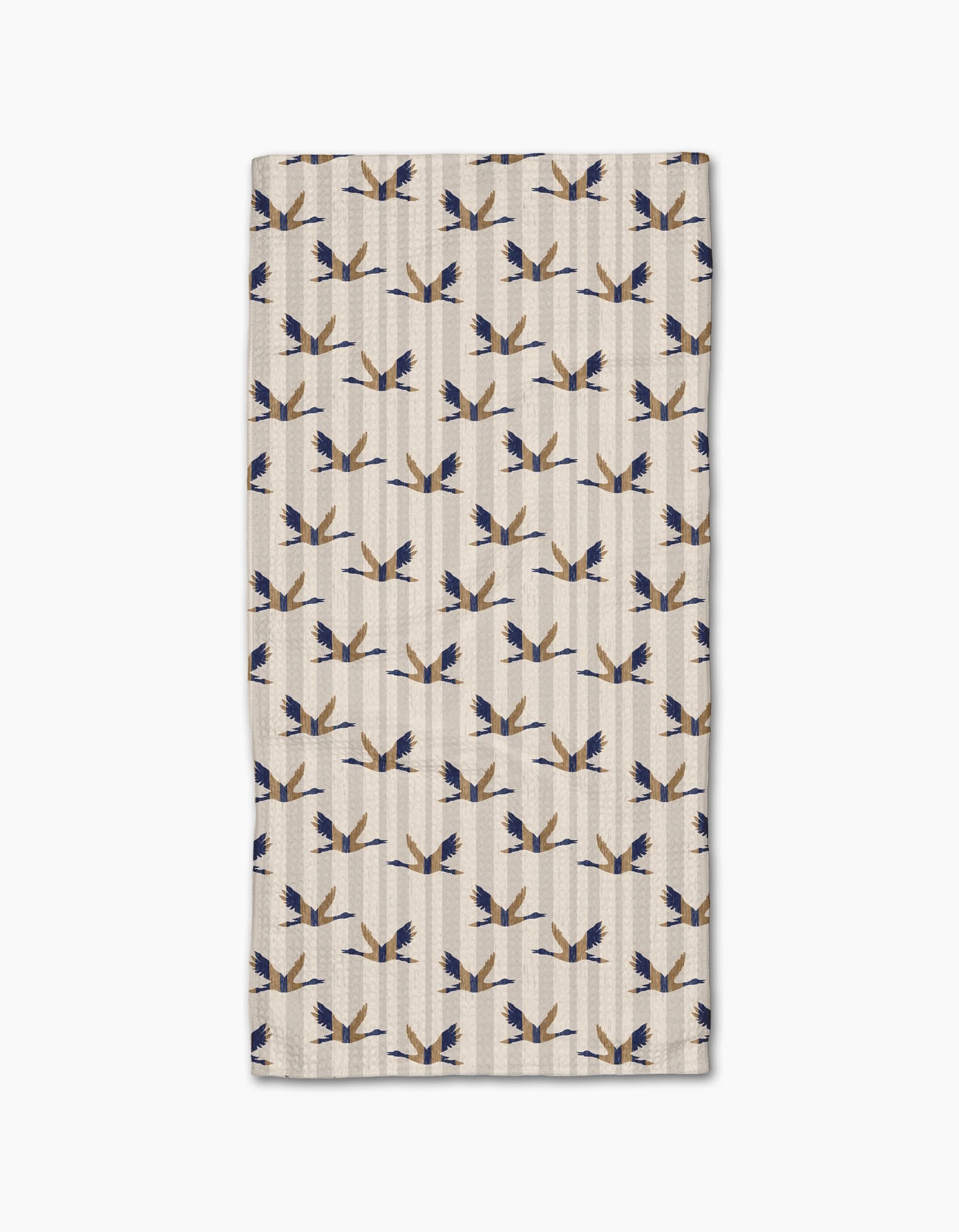 The Geometry Striped Nautical Birds Bar Towel is beige with a symmetrical pattern of abstract blue and tan birds on Geoweave fabric, offering superior absorbency and durability.