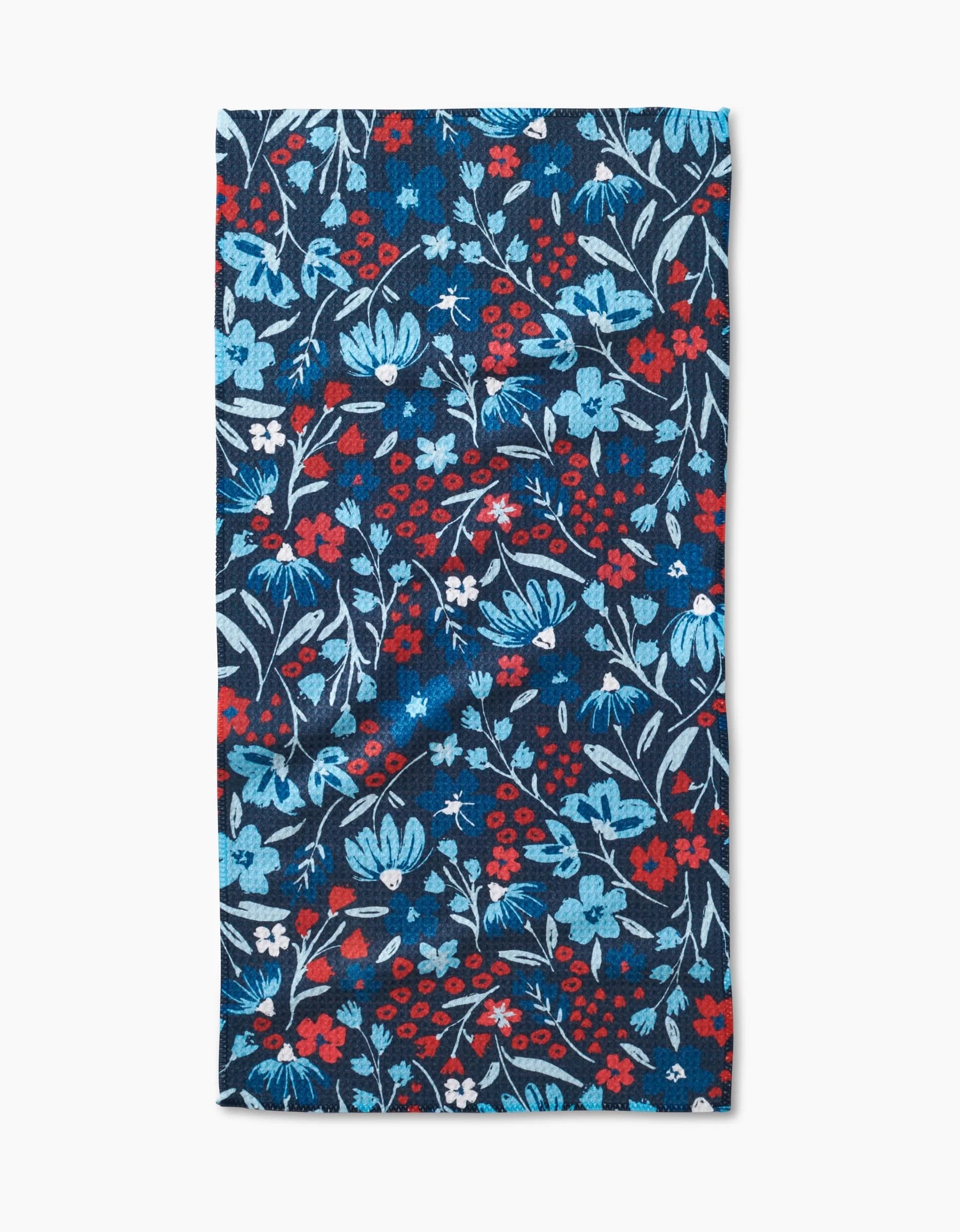 The Hufton Studio Summer Bloom bar towel features a rectangular Geoweave fabric with a floral pattern in blue, red, and white on a dark blue background, showcasing scattered flowers and leaves.