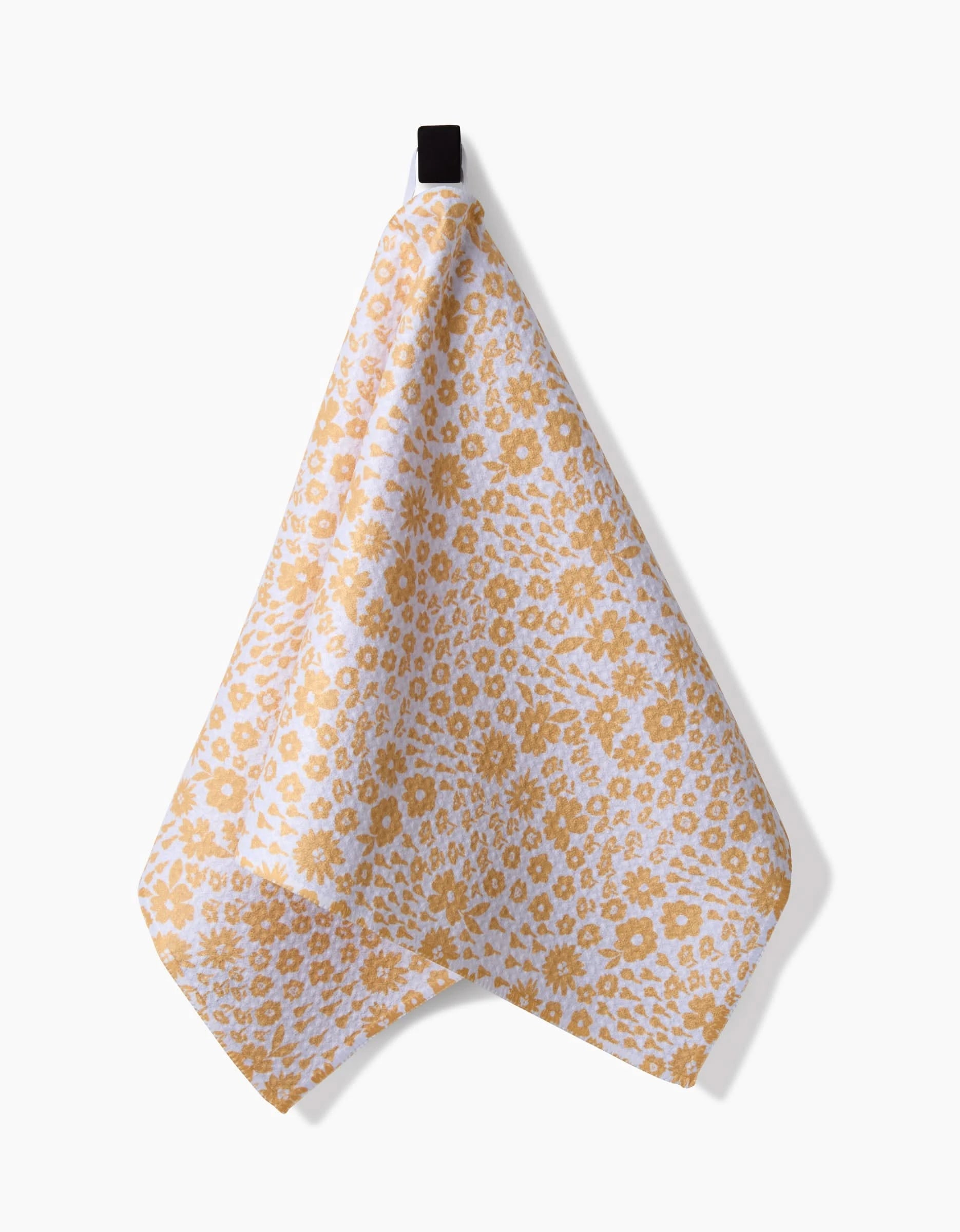 The Summer Fields bar towel by Hufton Studio, featuring a yellow floral pattern on white and made from recycled materials, hangs from a black loop against a plain white background.