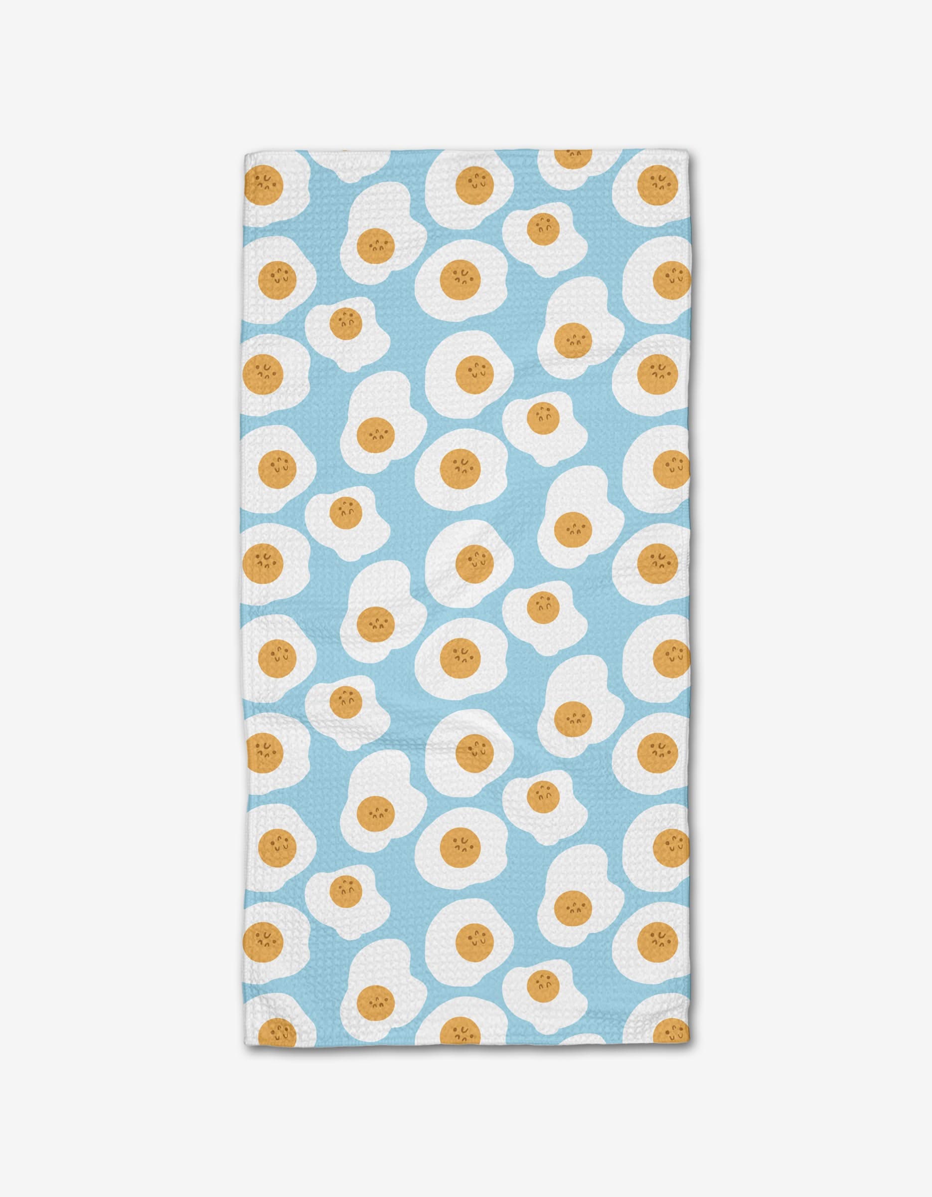The Sunny Side Up bar towel by Janna Sue Design is rectangular, made from recycled materials, and features a light blue background with a repeating pattern of smiling cartoon fried eggs.