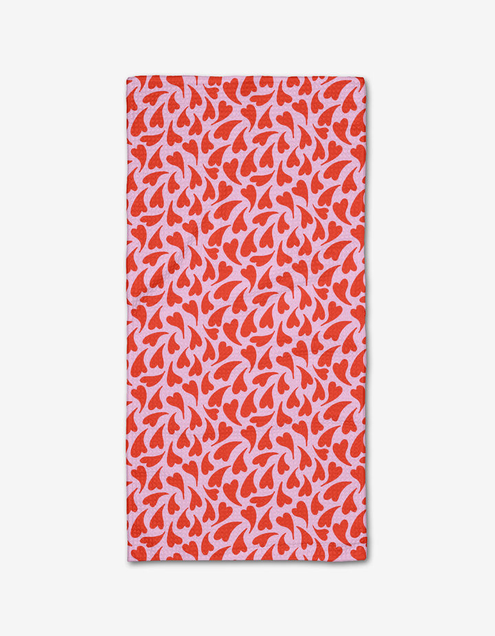 The Kayla Ann Swooning Hearts bar towel features red and pink abstract heart motifs on a light pink background, displayed flat on a white surface.