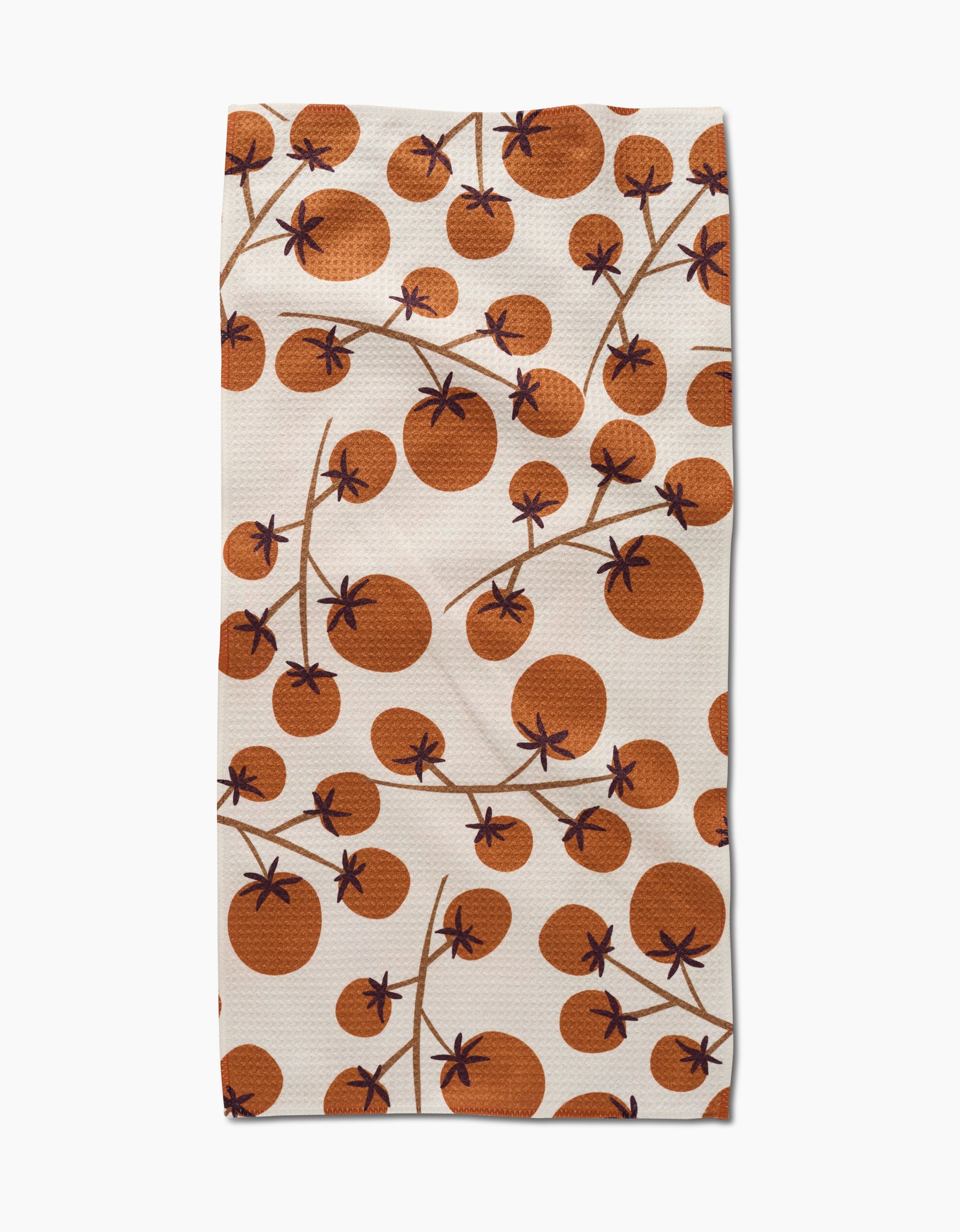 The Lizzie Clark Tomato Harvest bar towel features a repeating pattern of orange tomatoes with brown stems and leaves on white Geoweave fabric for superior absorbency.