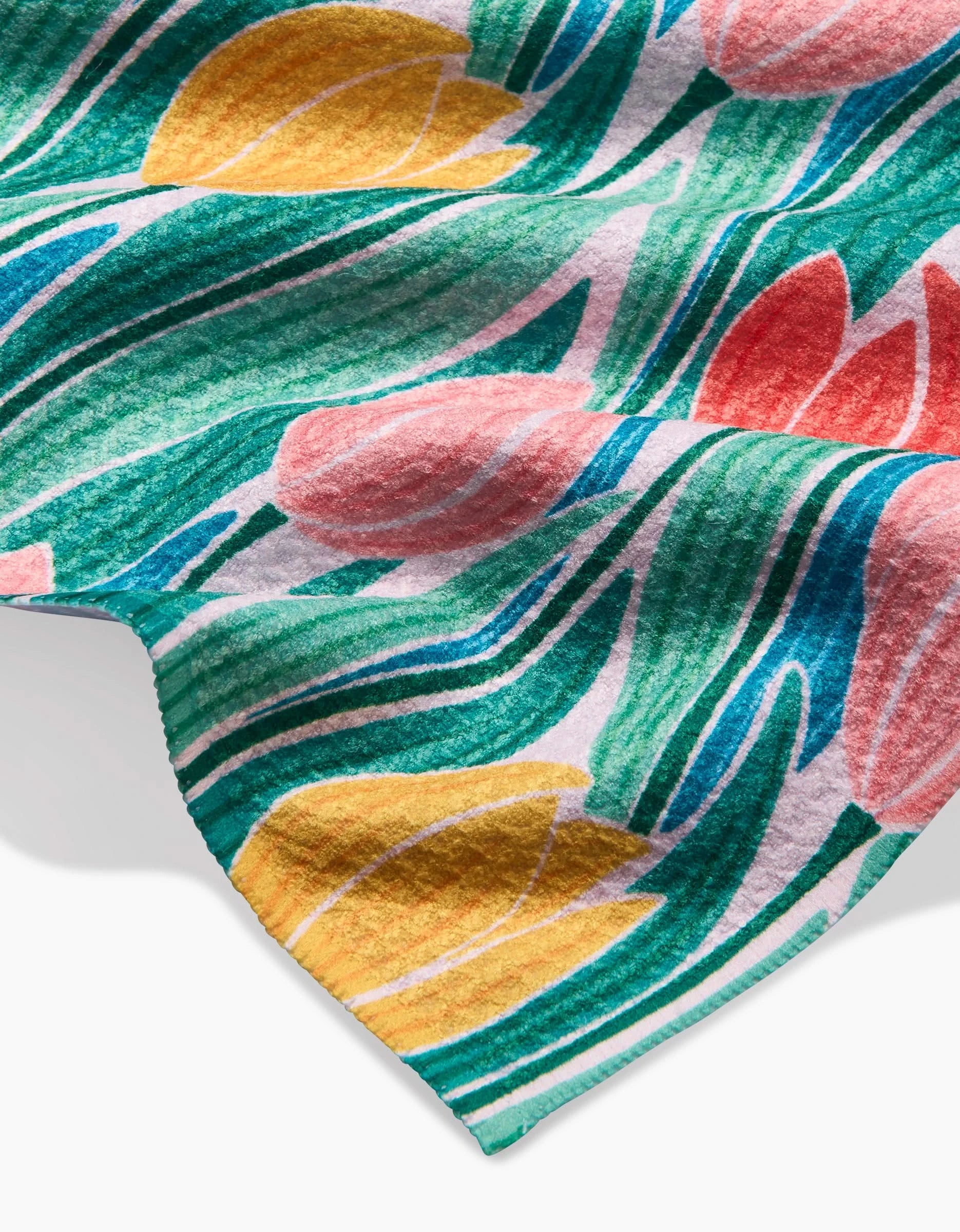 A close-up of the Sarah Daugherty Tranquil Tulips bar towel, made from Geoweave fabric and featuring a floral design with yellow and pink tulips, green leaves, and flowing blue accents on a white background.