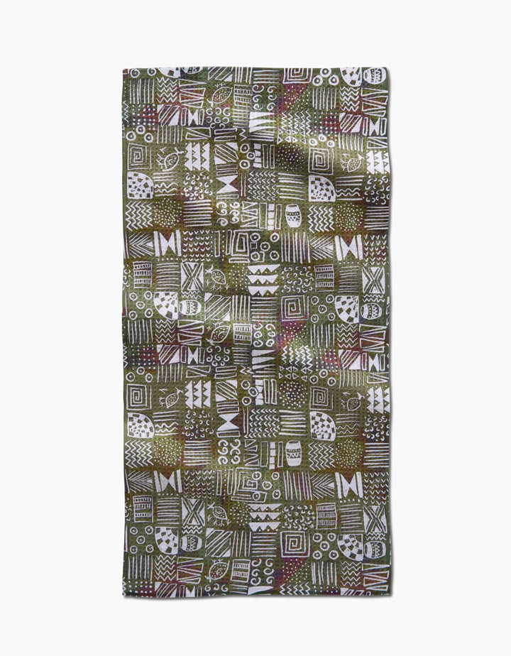 The Tribal Symbols bar towel by Taryn Brennan features eco-friendly Geoweave fabric with a green background and hand-drawn white, brown, and red geometric patterns arranged in a bold grid.