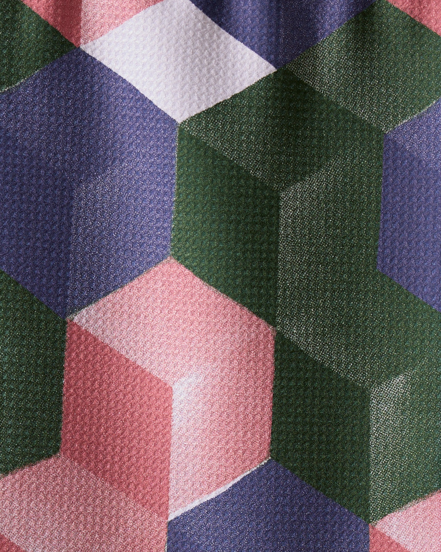 Close-up of the Geometry Tumble bar towel, made from recycled materials. Features a geometric cube pattern in green, pink, white, and dark blue for a 3D effect on ultra-absorbent, textured fabric.