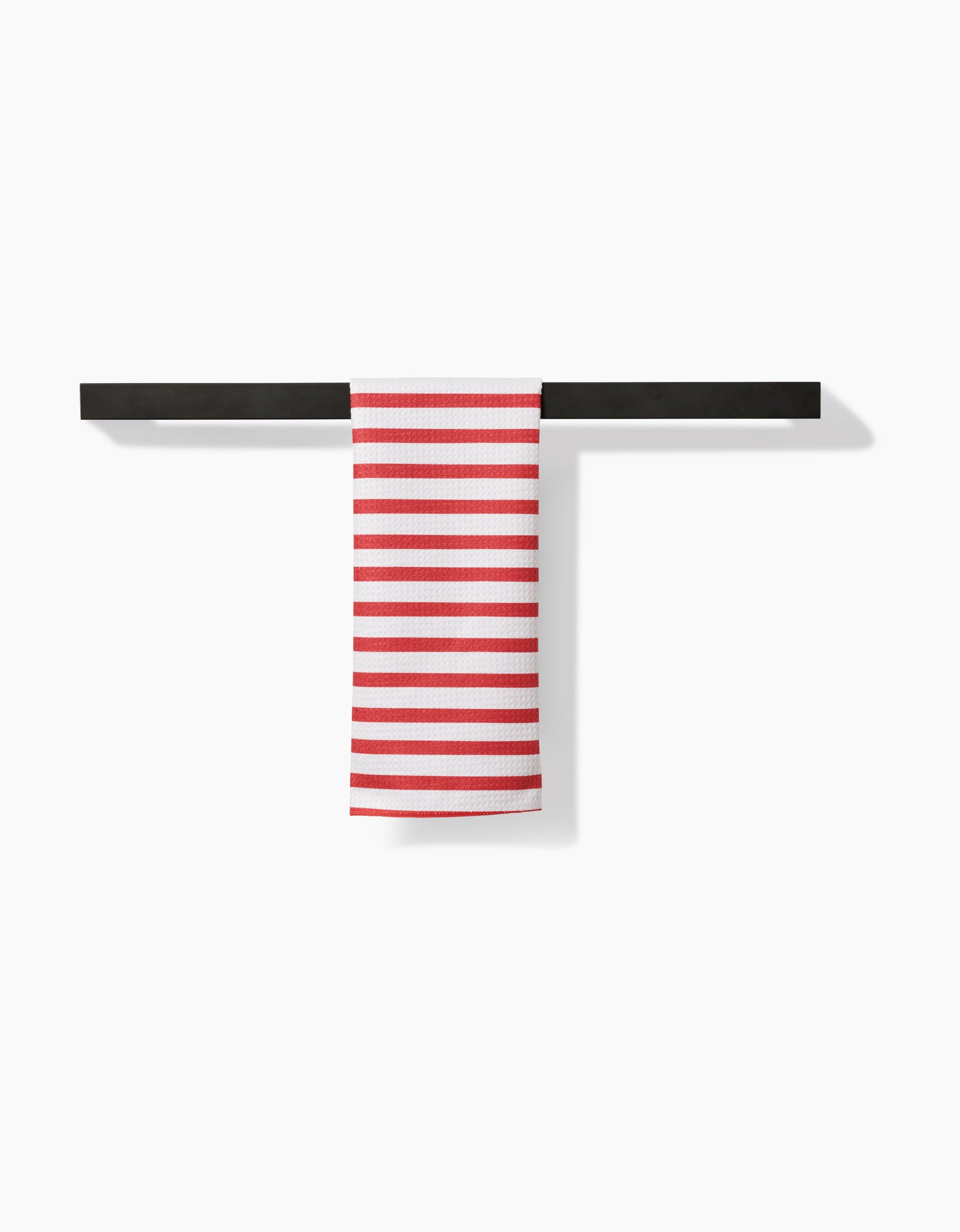 The Mindfulnice USA Stripes bar towel, made from recycled materials, features white fabric with horizontal red stripes and is displayed over a sleek black towel bar against a plain white background.